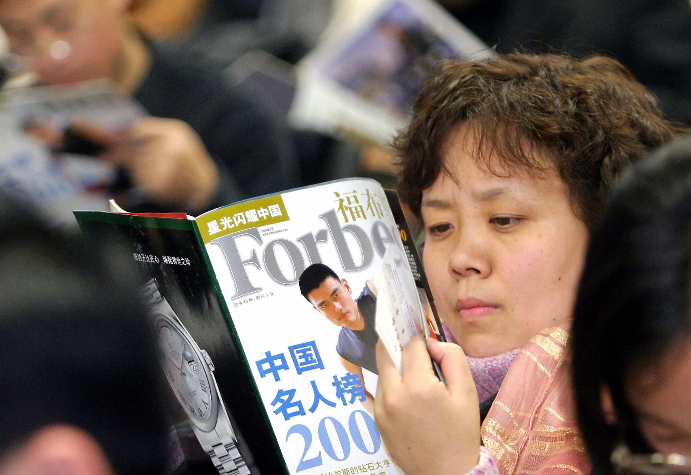 A Chinese woman reads Forbes
