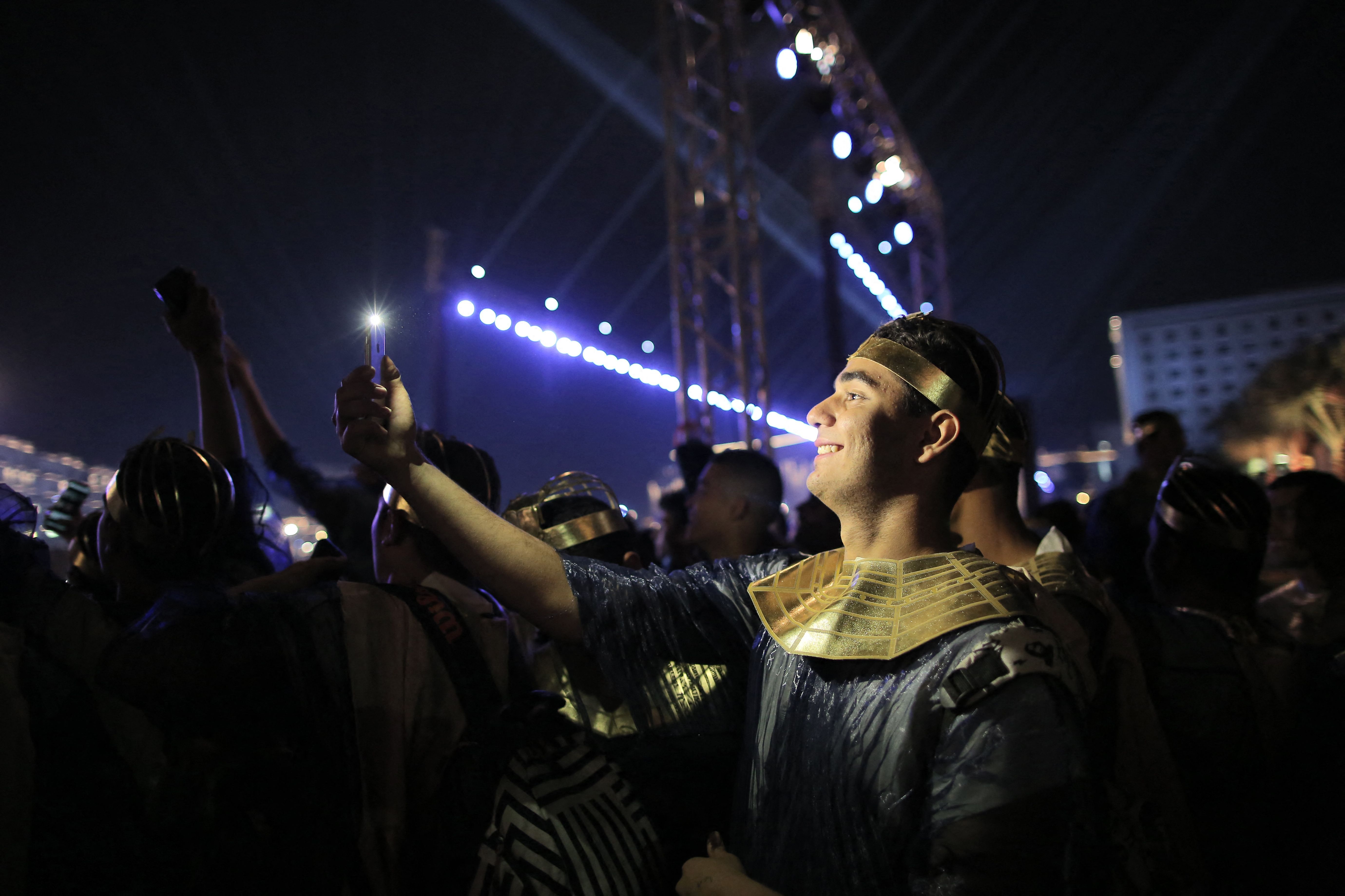 A performer dressed in ancient Egyptian costume uses his phone to take a "selfie" photo after the end of the parade of 22 ancient Egyptian royal mummies 