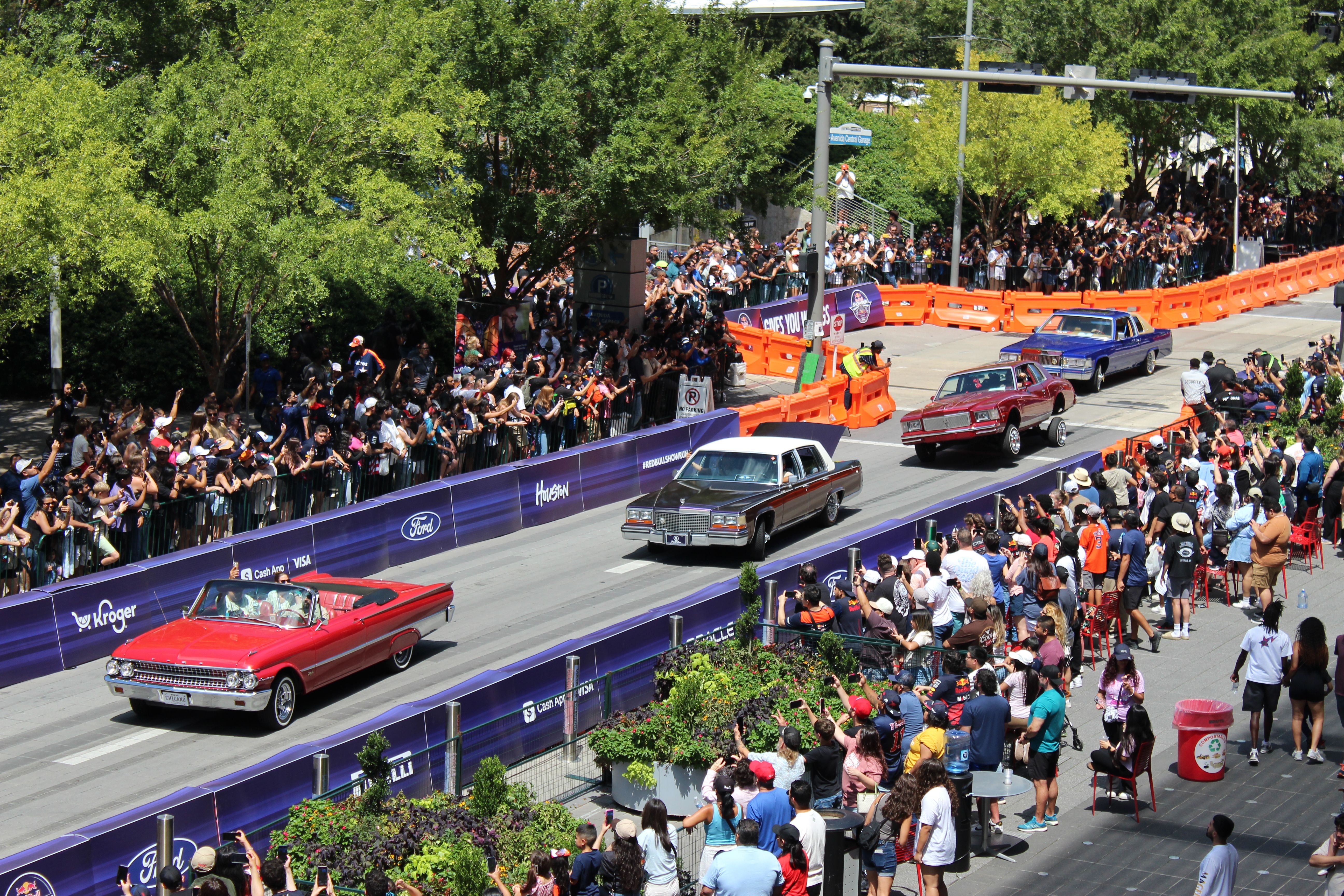 four low riders drive in downtown Houston
