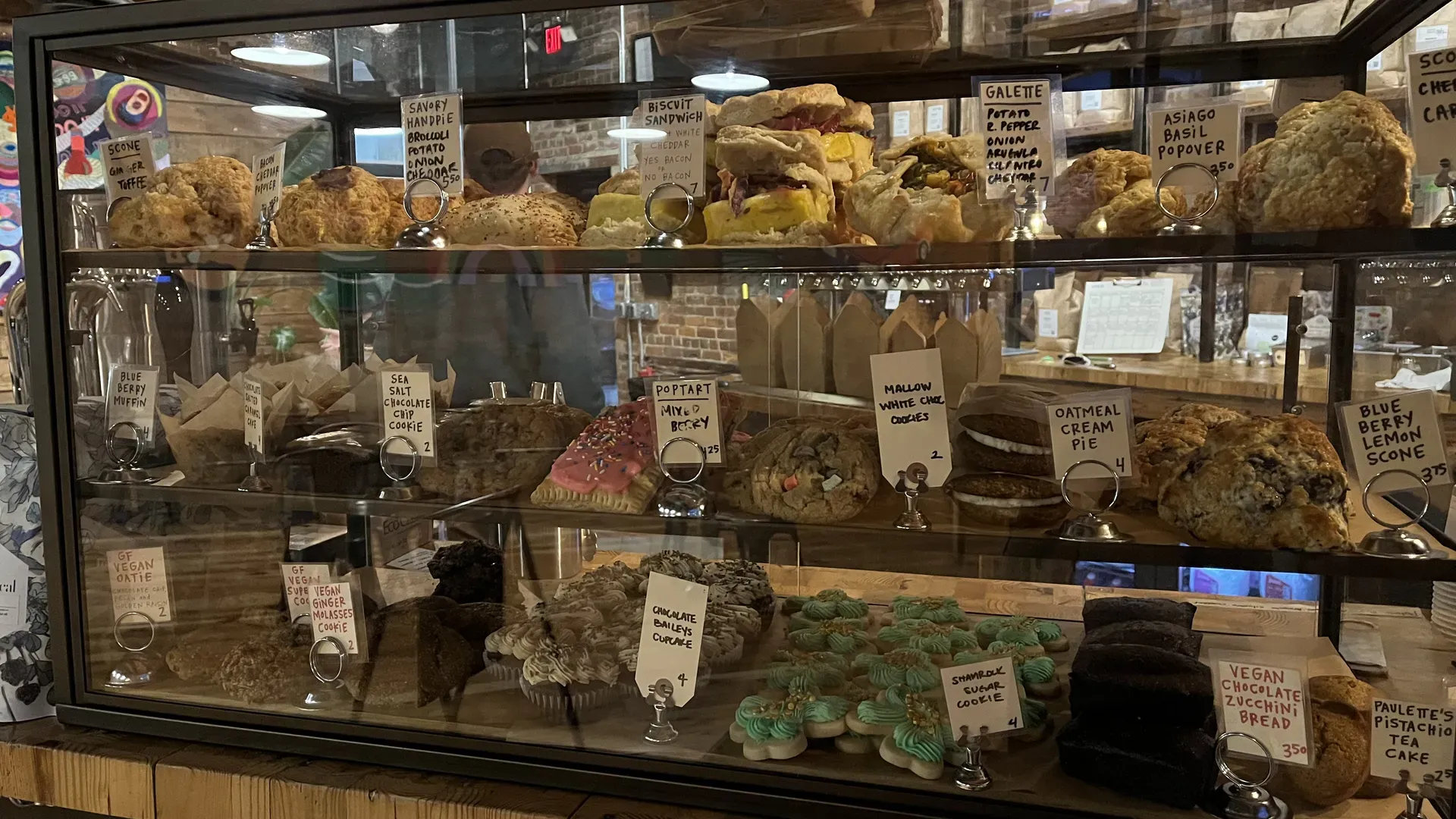 A glass case of tons of different baked goods. scones, pop tarts, cookies, brownies, etc.