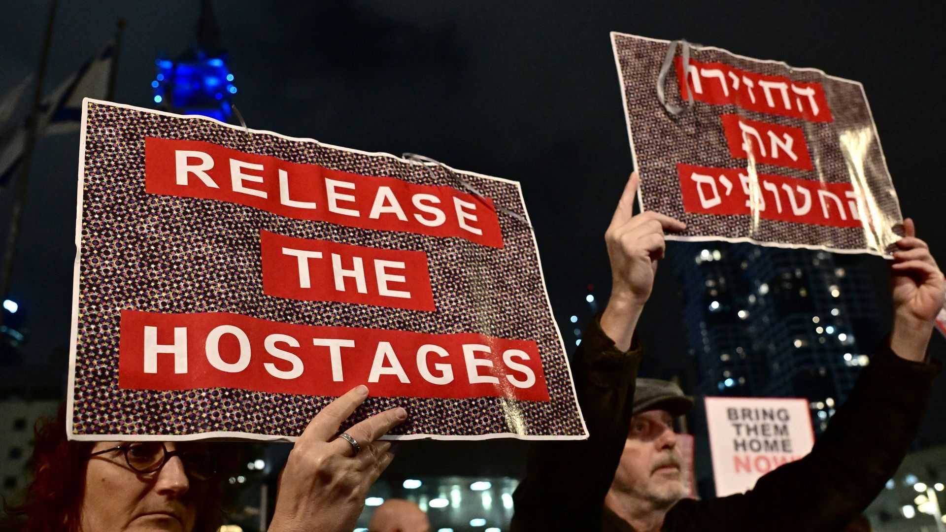 Protesters in Tel Aviv lift placards during a rally for supporters and relatives of Israeli hostages held in Gaza. Photo: Alberto Pizzoli/AFP via Getty Images