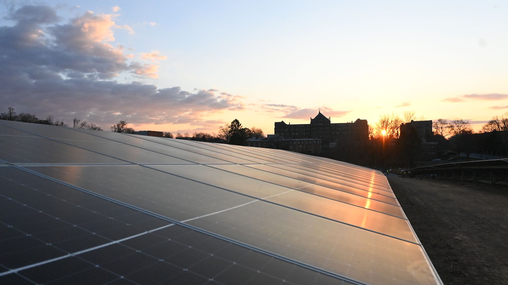 A field of solar panels at sunset 