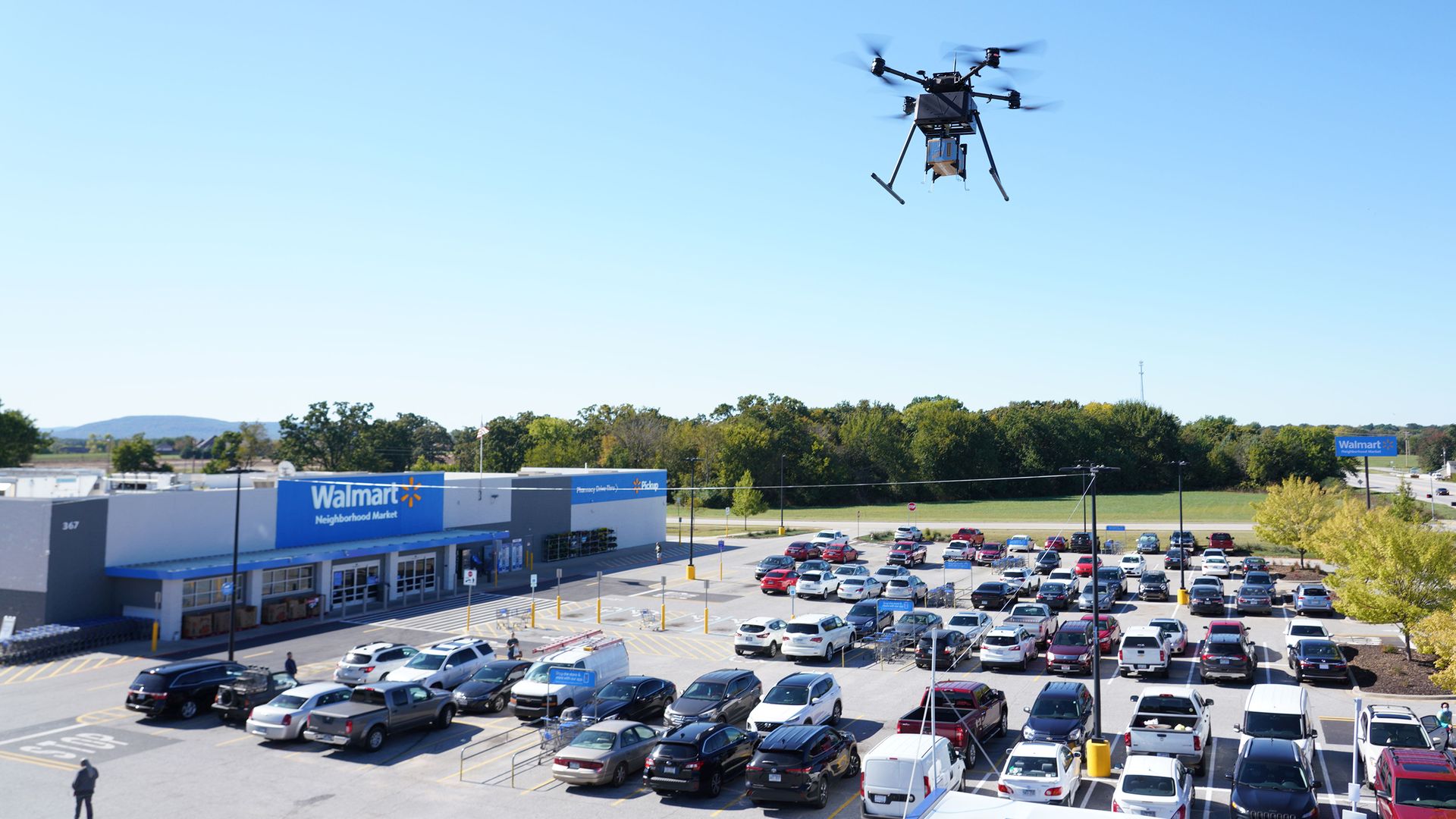 A Walmart drone flies over a store parking lot.