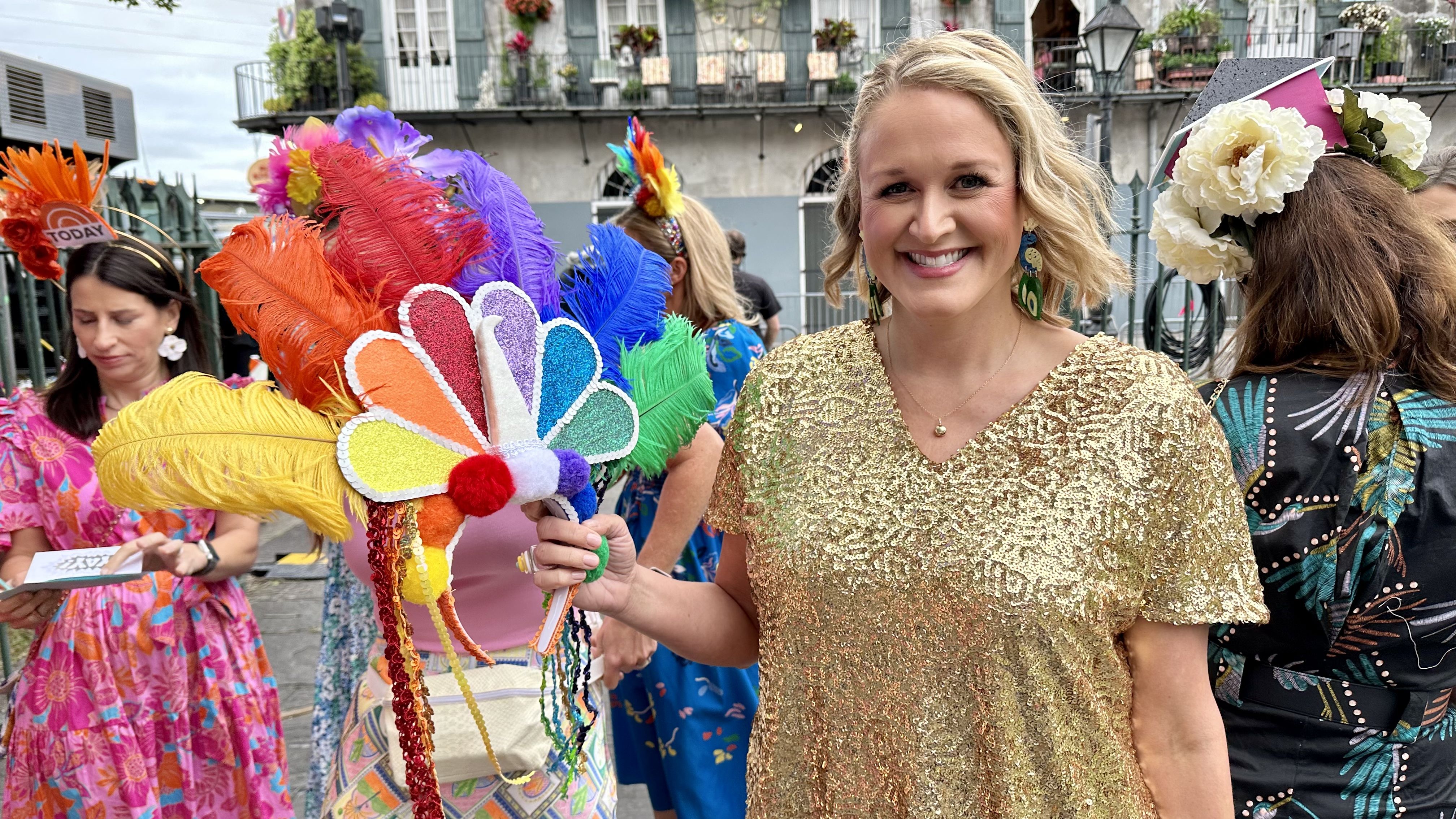 Photo shows a woman with an NBC peacock feathered head dress.