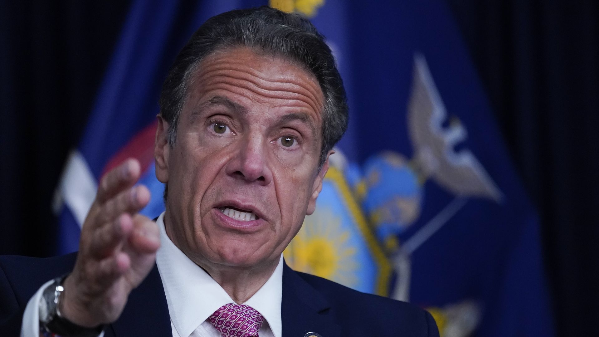 Photo of Andrew Cuomo raising his right hand while speaking
