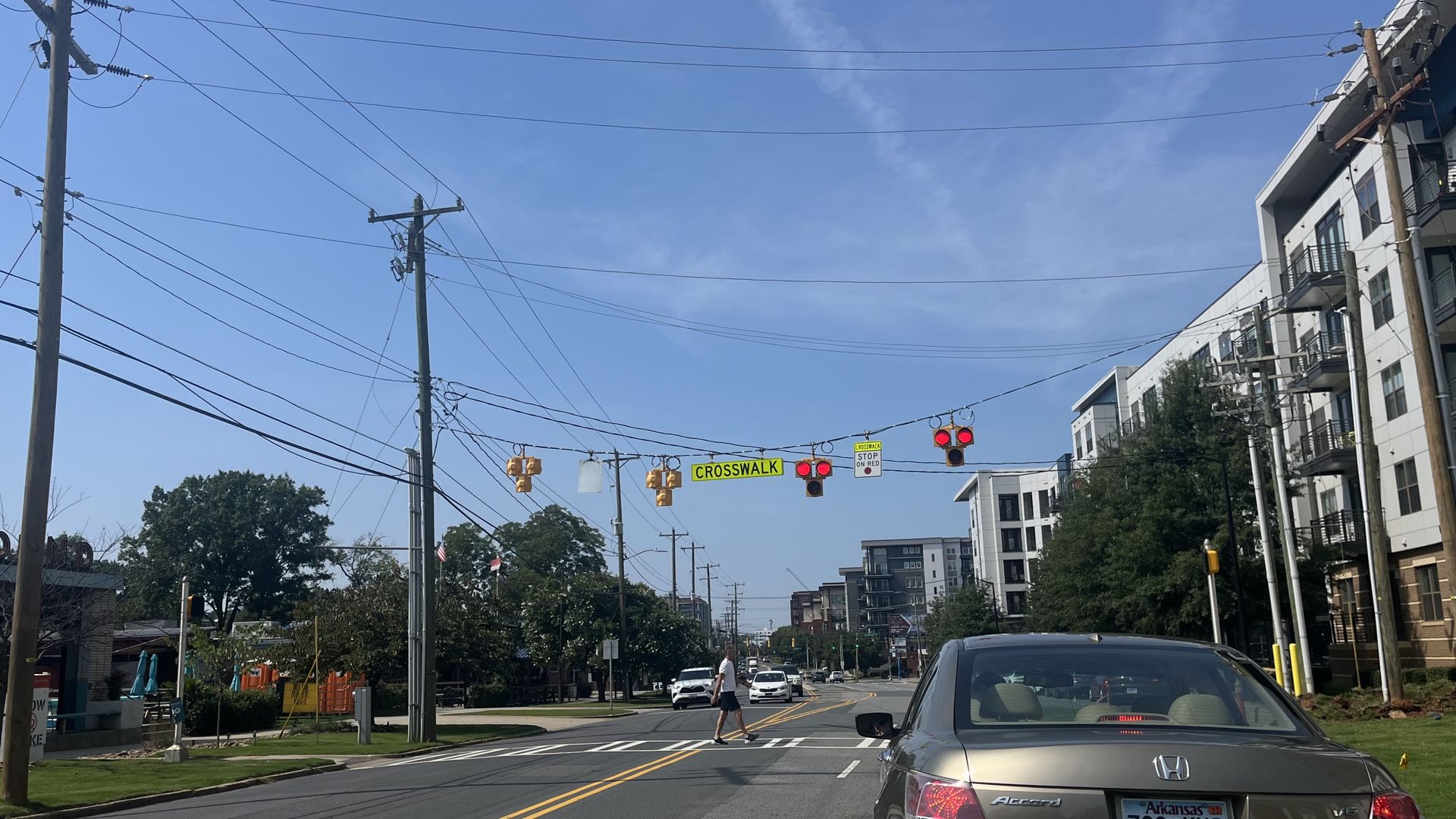 Person crosses a crosswalk in front of a stopped card