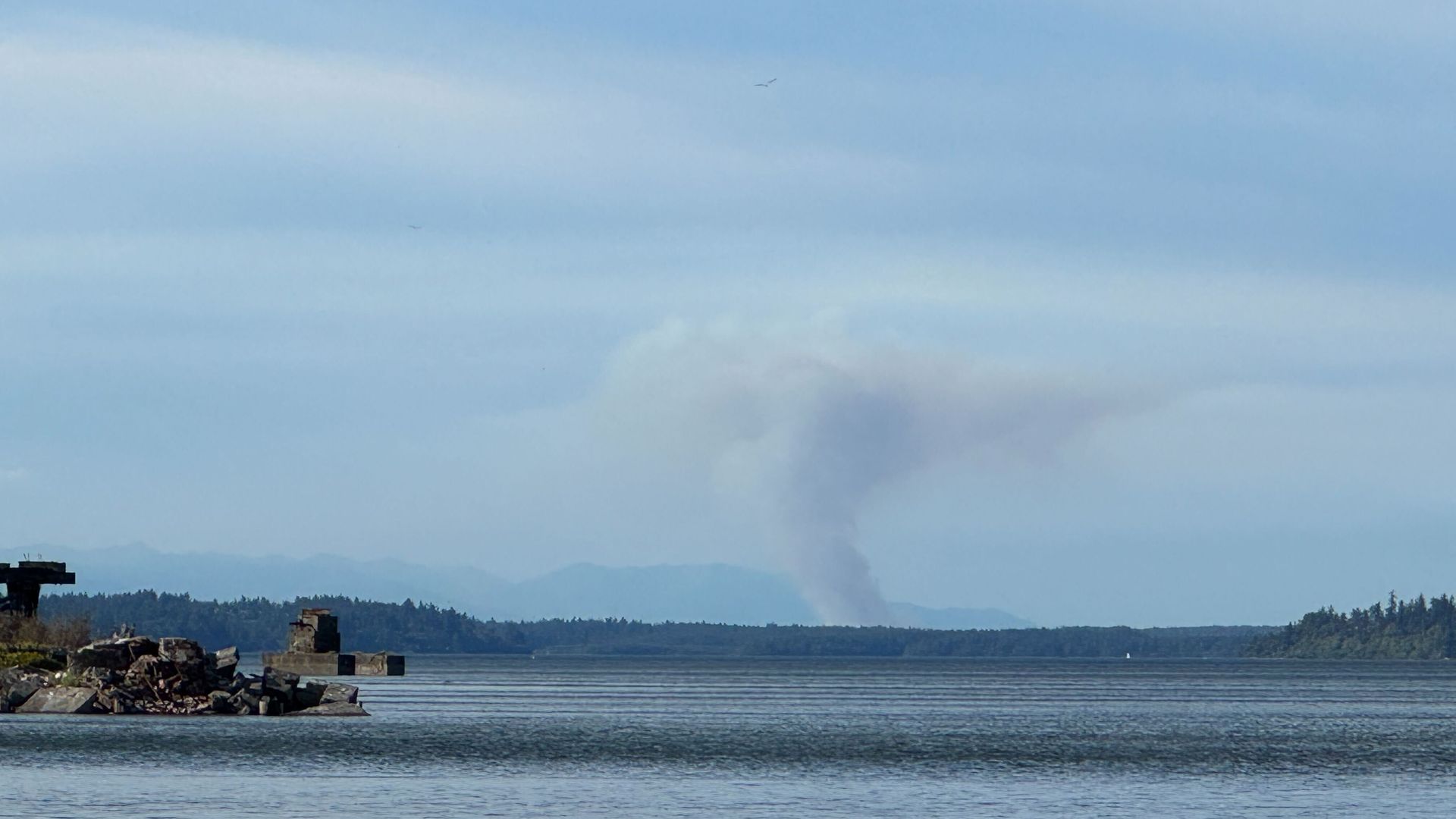 A plume of smoke is seen in the background over West Bay in Washington state. 