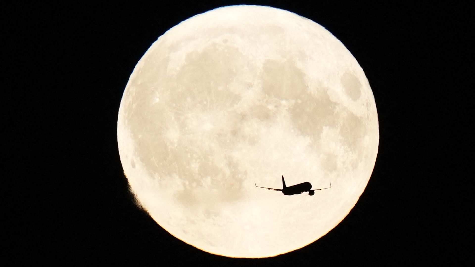 Aircraft flies in front of the Super Blue Moon over Copenhagen, Denmark