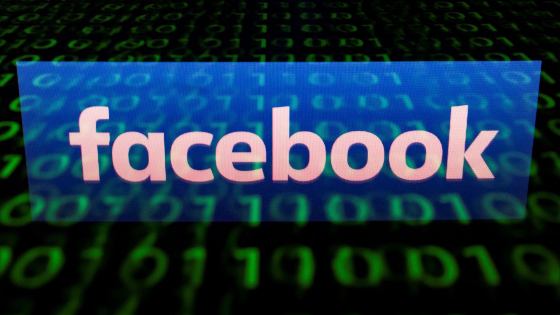Facebook logo displayed on top of coding