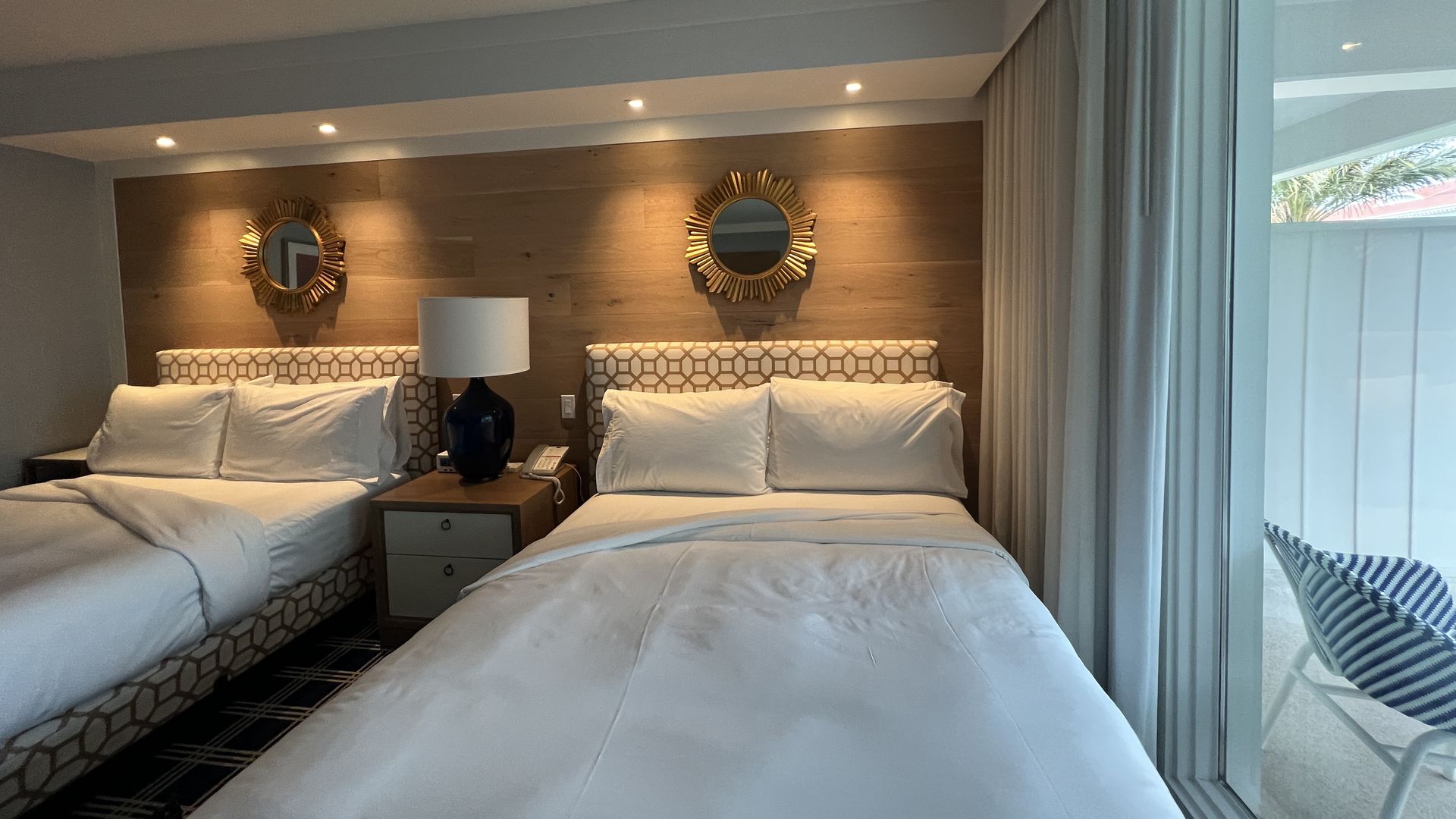 Two beds in a hotel room with overhead lighting