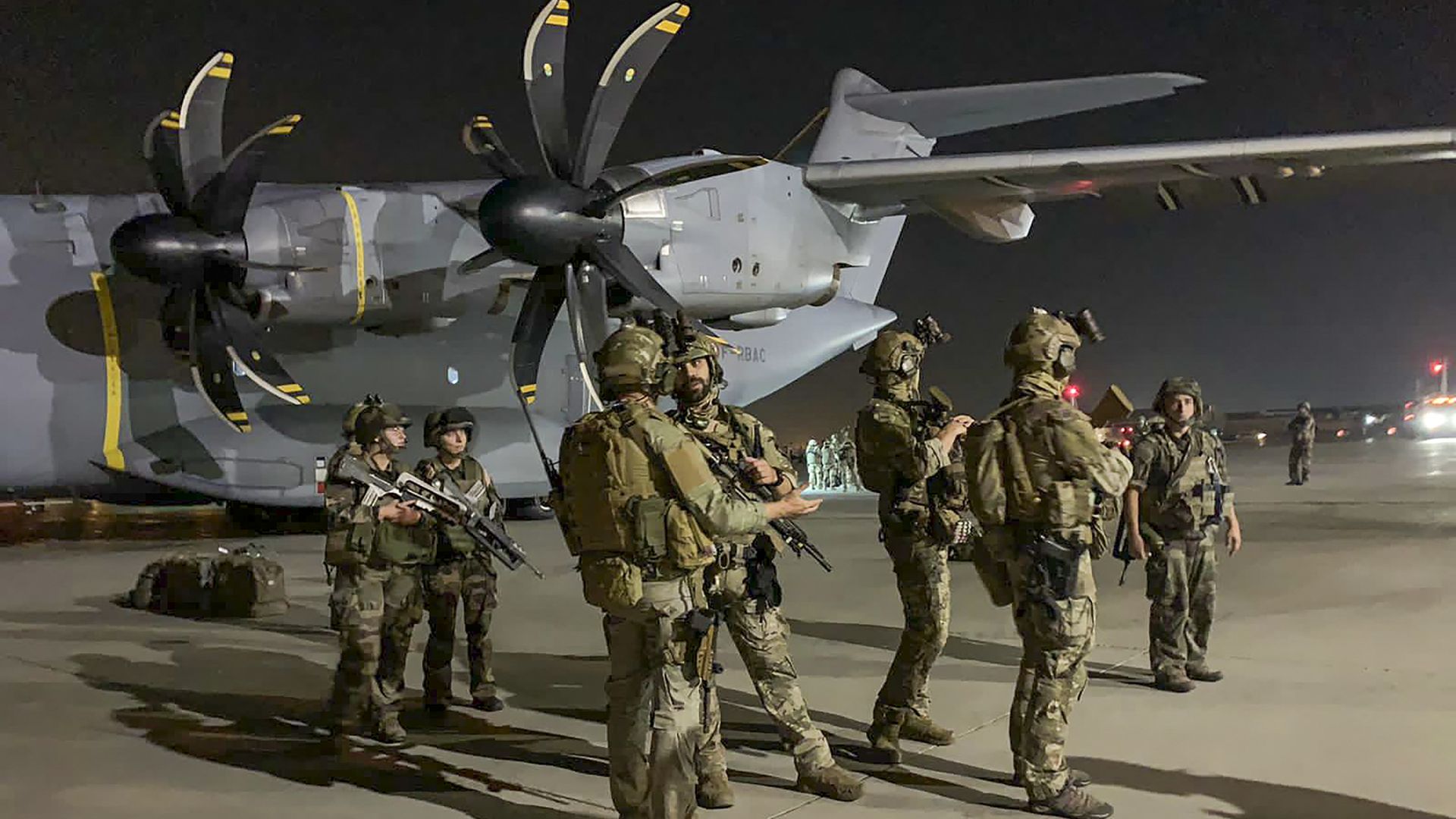 French Special Forces Soldiers stand guard near a military plane 