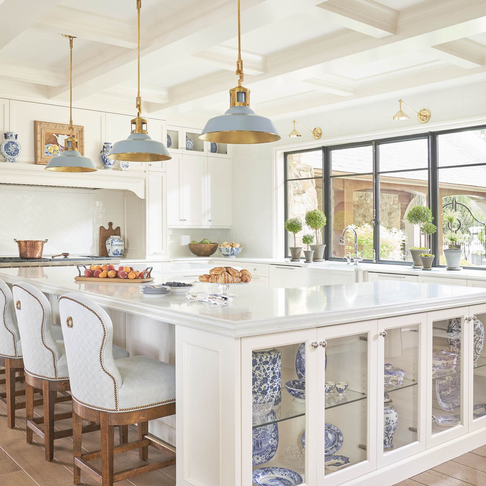 luxury kitchen with a u-shaped island and blue and white ginger jars spread around