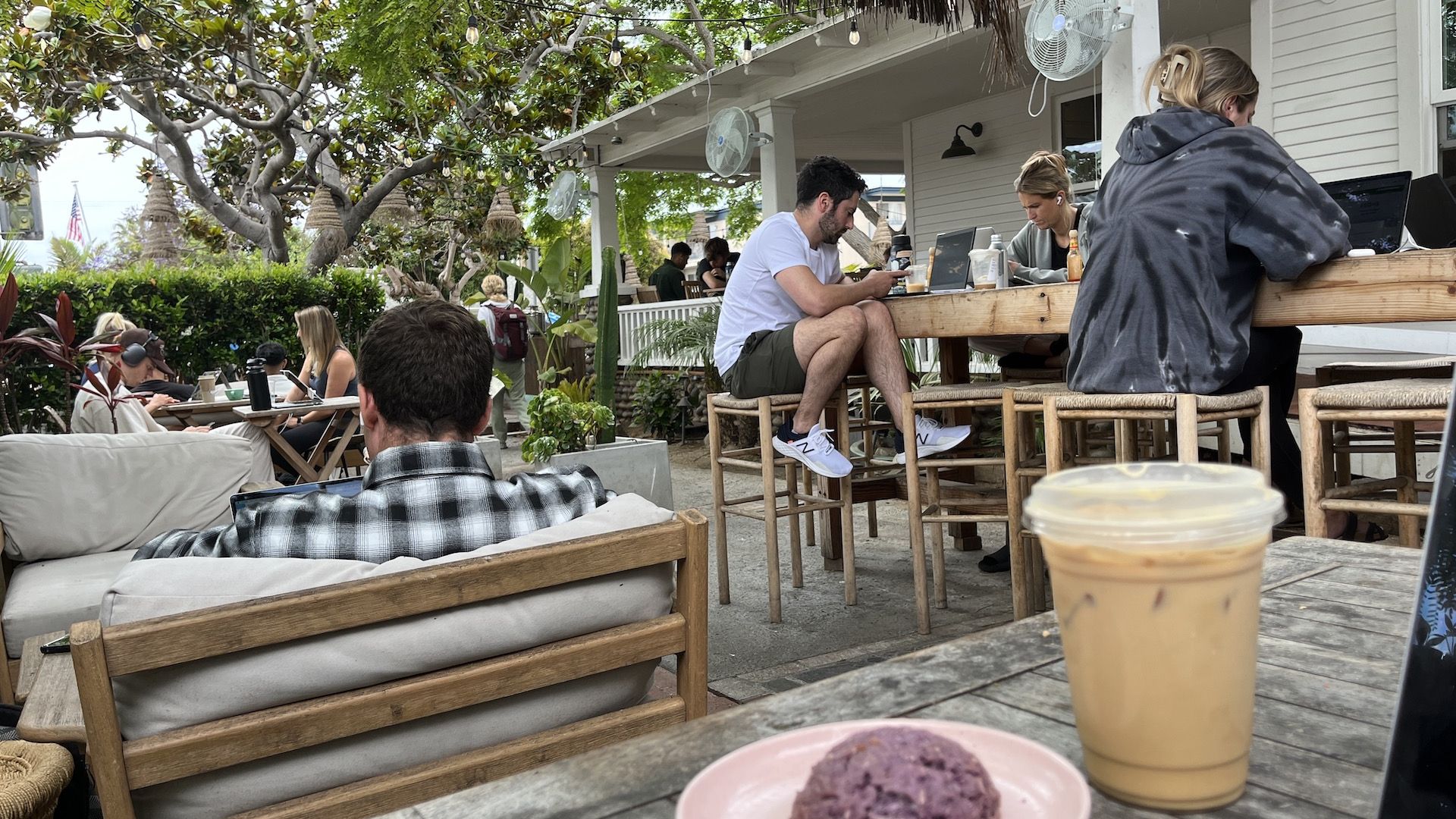 Remote workers sit at a beachside outdoor patio 