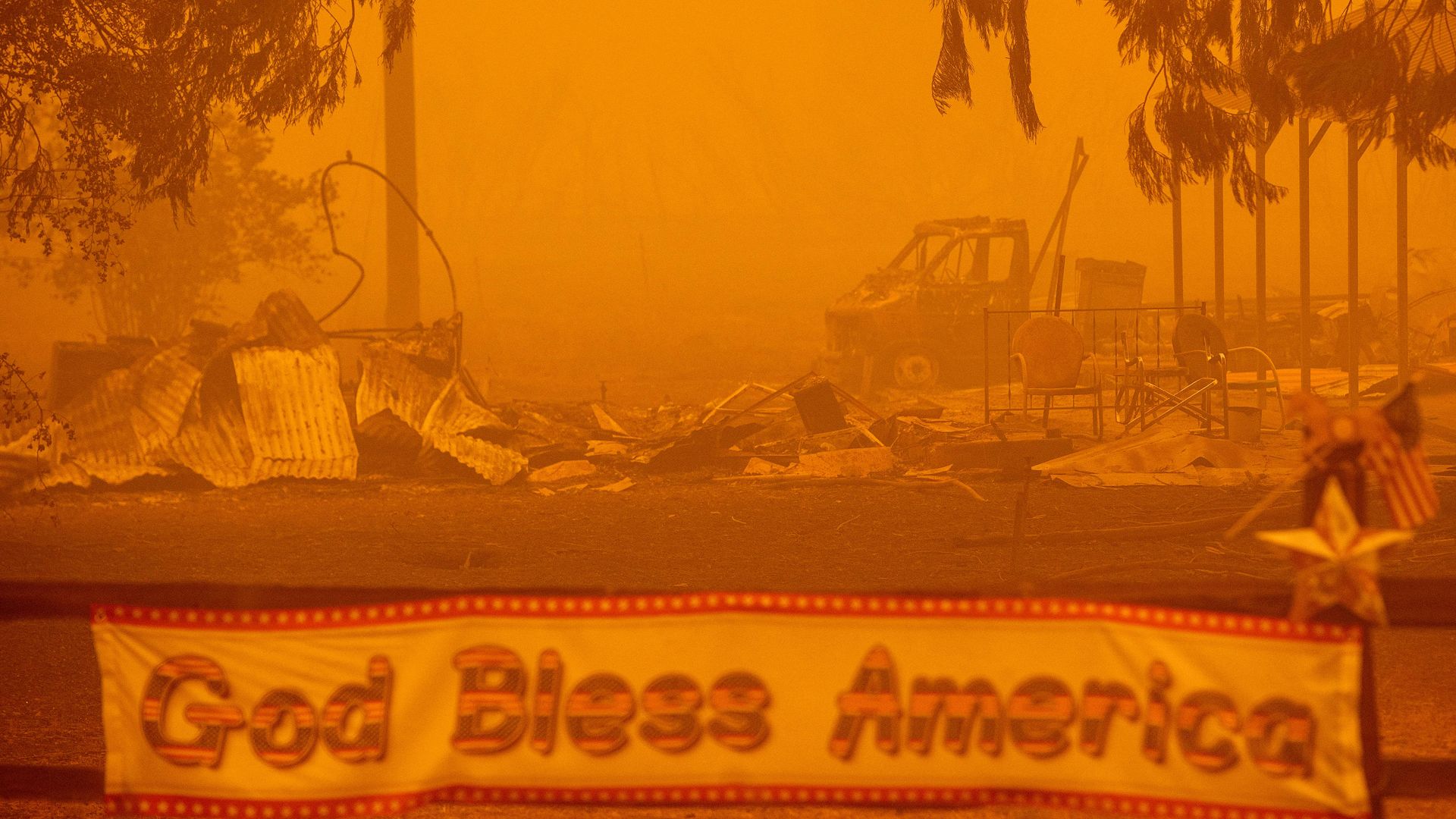 A patriotic banner is seen in front of a burned out property during the Dixie fire in Greenville, California on August 6