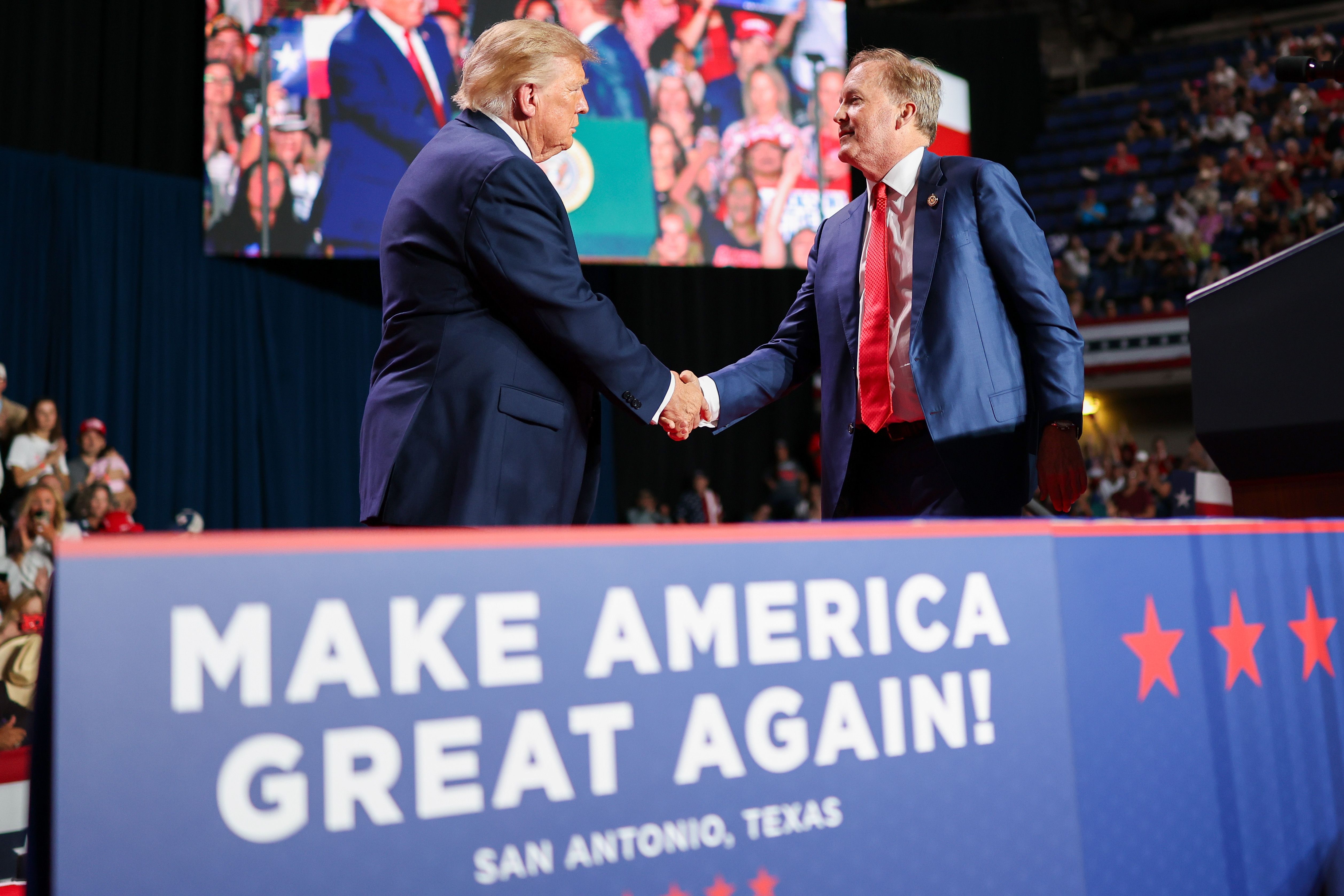 President Trump shakes hands with Republican Senate candidate Ken Paxton at a rally in San Antonio yesterday.