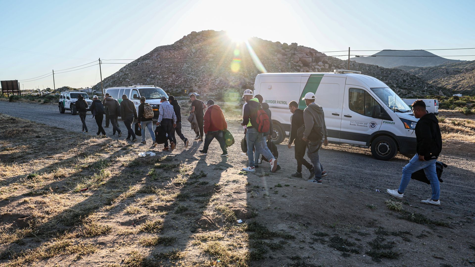 Migrants line up to be transported by Border Patrol after waiting in a makeshift camp near the I-8 freeway, after crossing the border through rocky, mountainous terrain.
