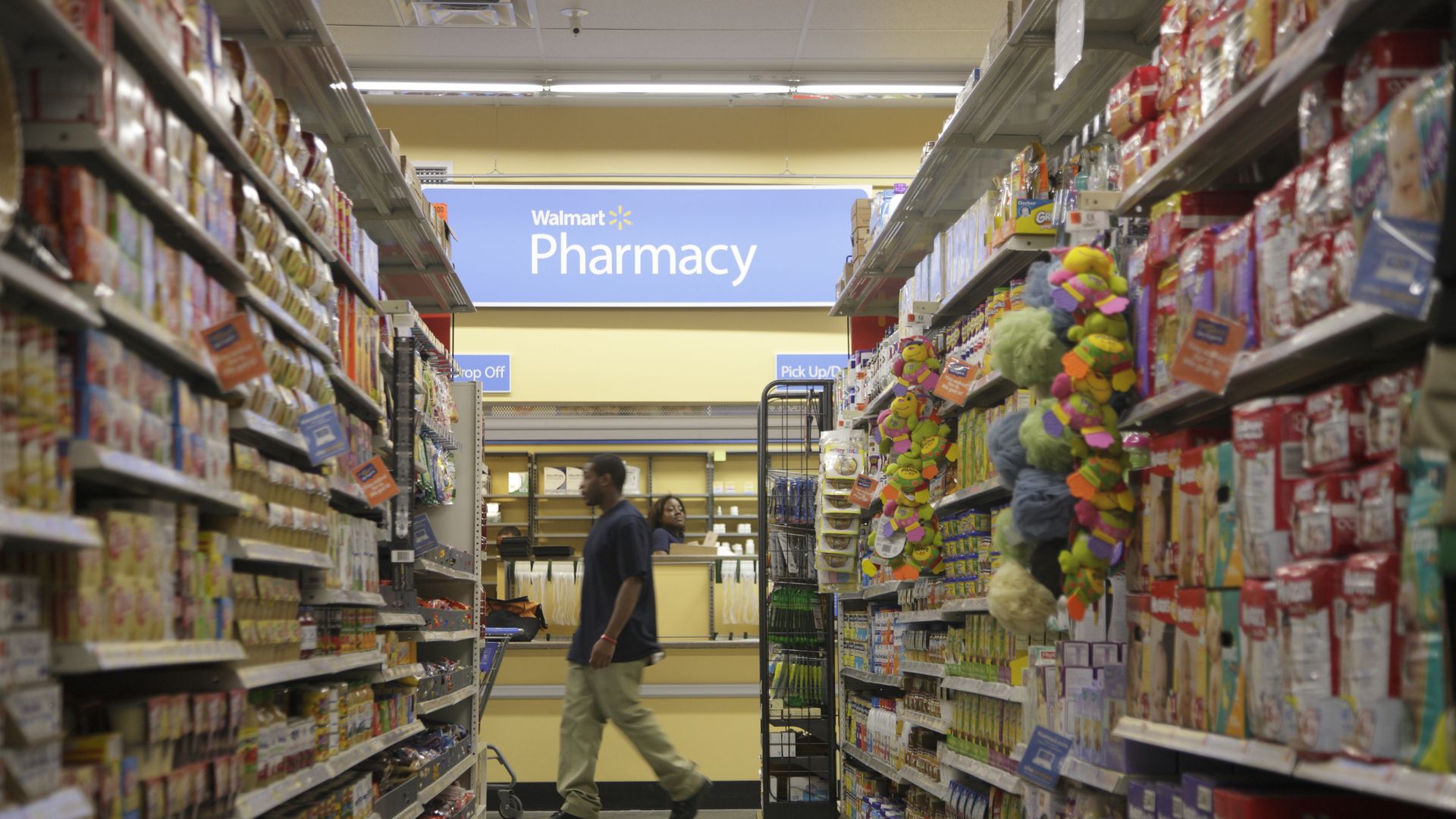 A man walks in front of an aisle near Walmart's pharmacy.
