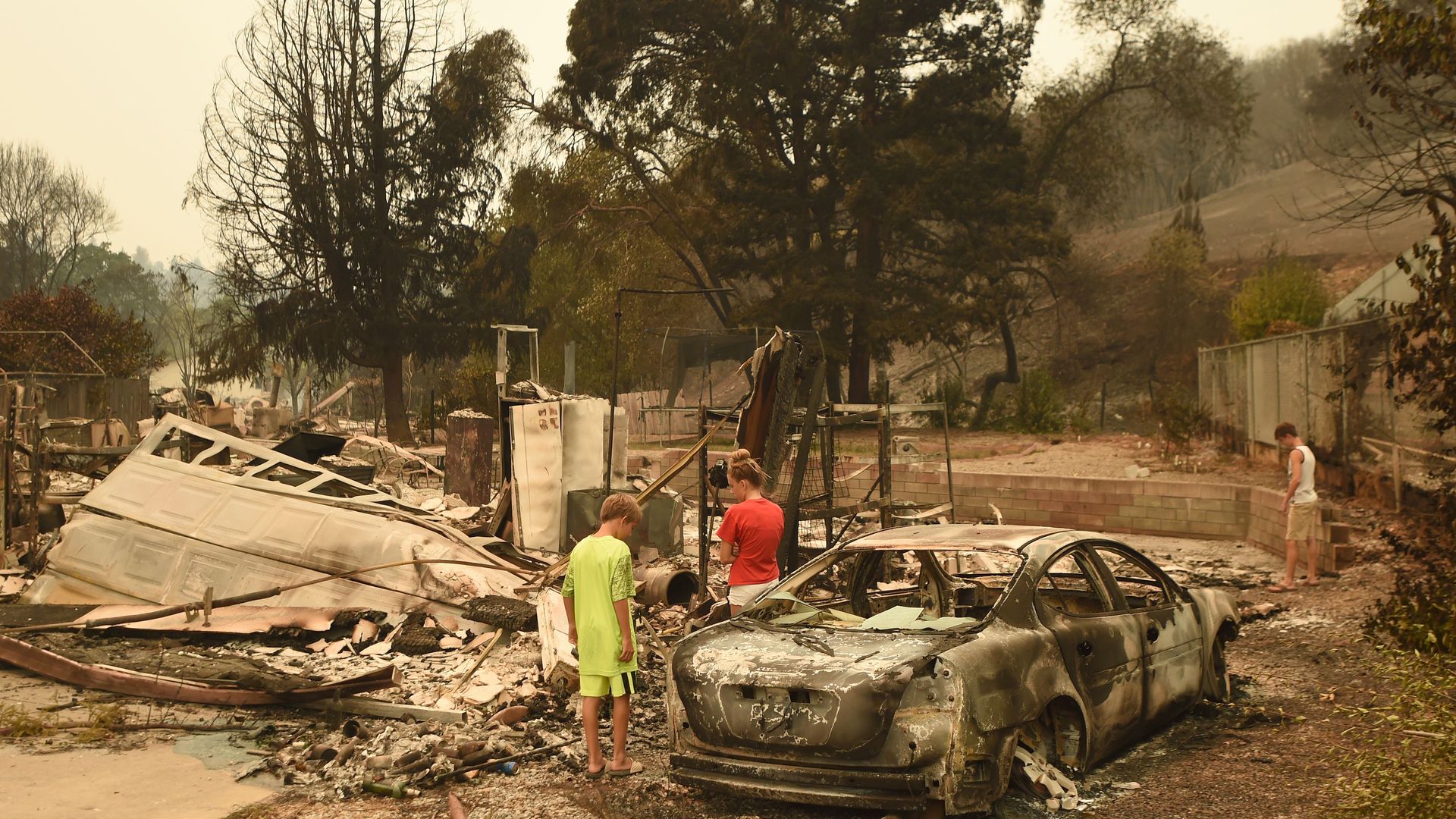 A family looking at the remains of their home.