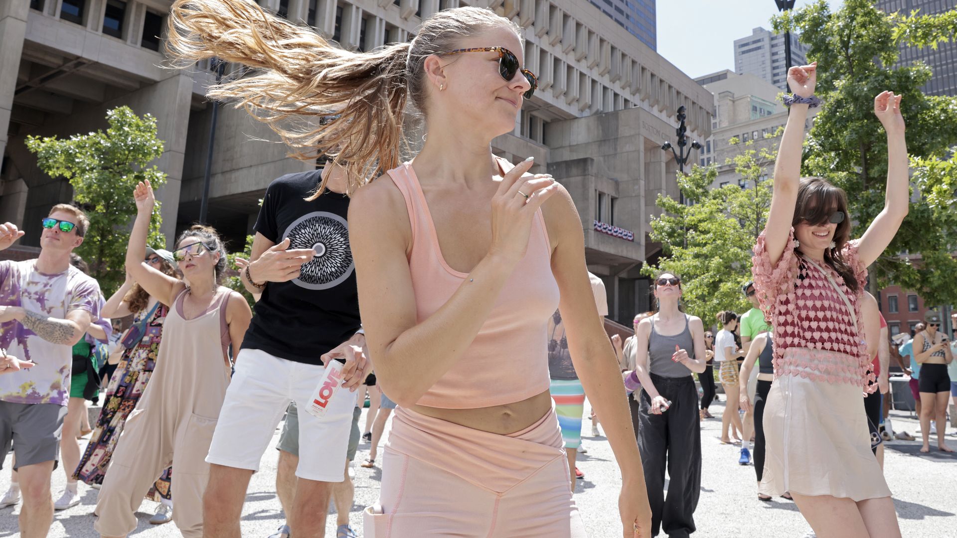  After warming up with mat Pilates, participants move to the sounds led by global MC Elliott LaRue (not shown). Daybreaker's "Have Fun Be Nice" wellness and dance party event takes place on City Hall Plaza on June 29, 2025. (Photo by Pat Greenhouse/The Boston Globe via Getty Images)