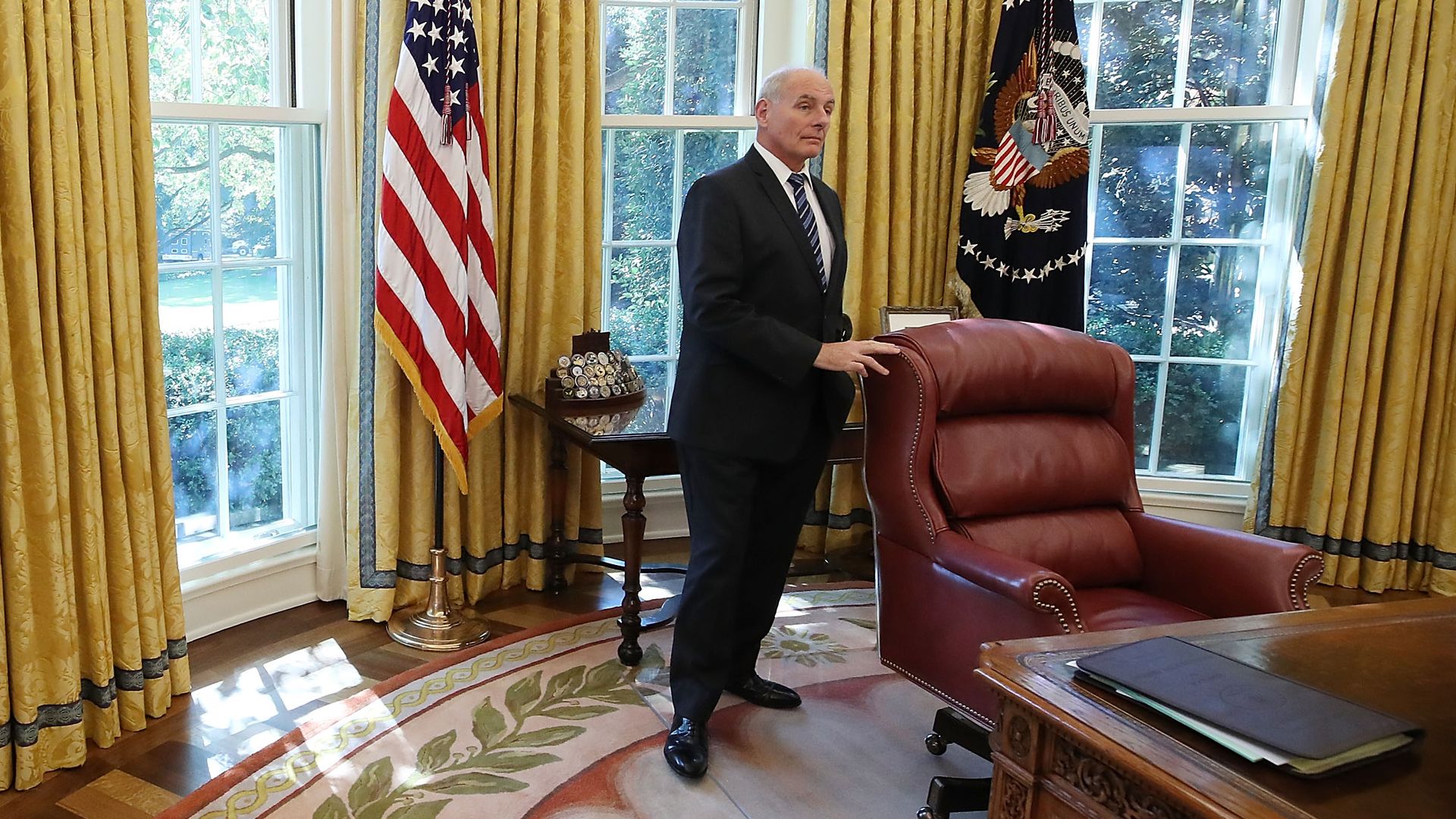 John Kelly stands behind the desk in the Oval Office