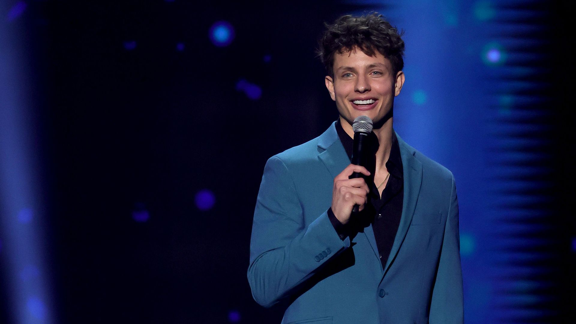 Comedian Matt Rifes performs on stage. 