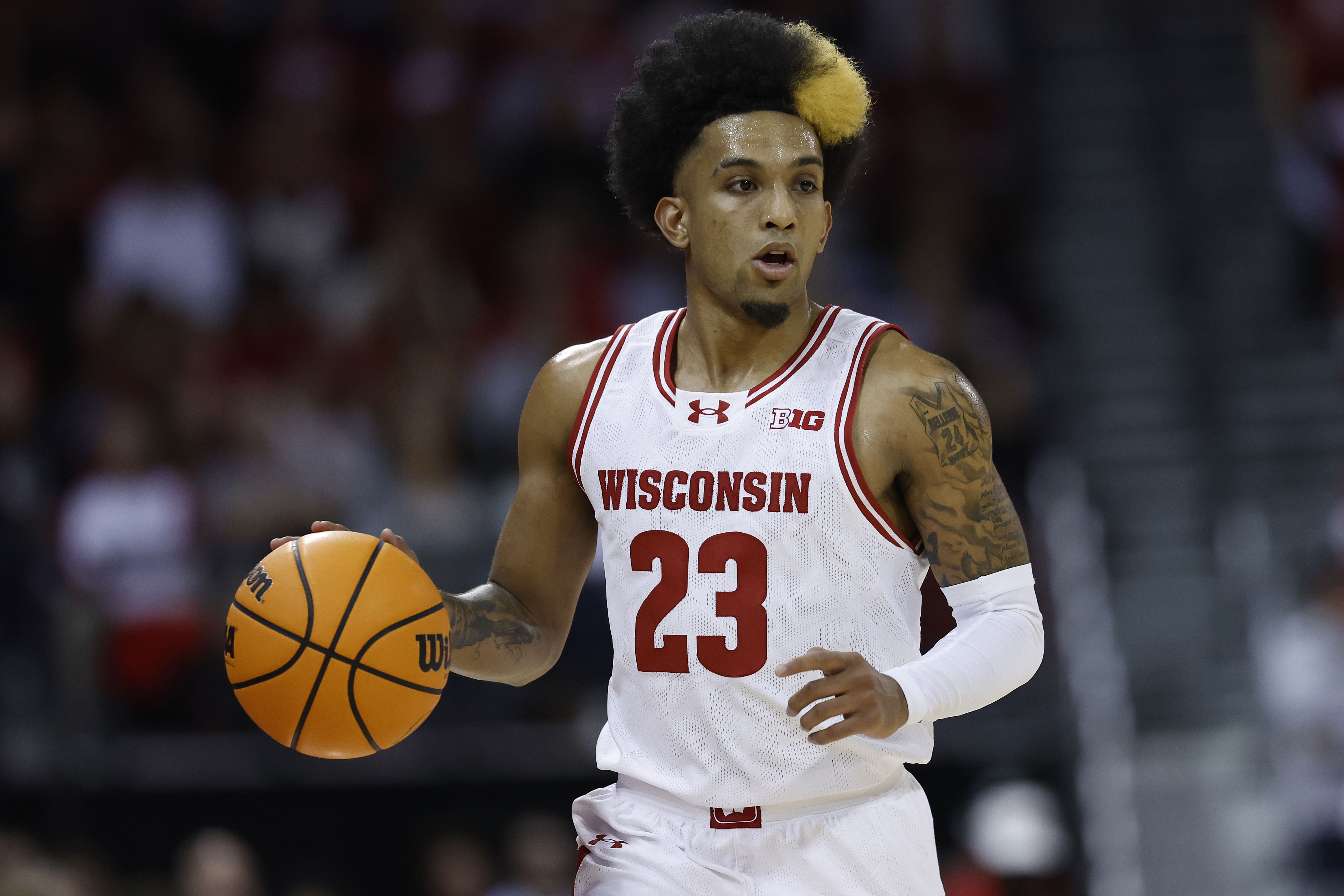 Photo of a basketball player bouncing a basketball on the court
