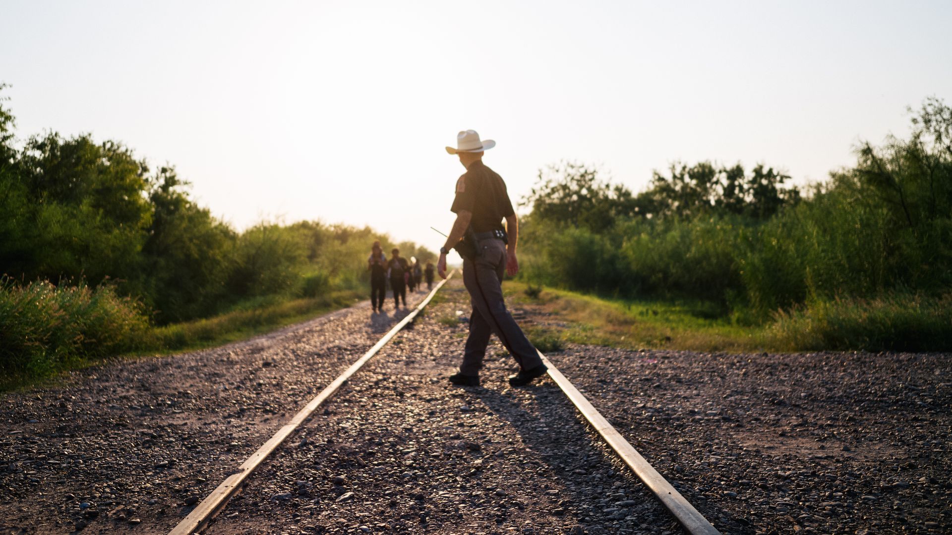 A Border Patrol agent is seen walking toward migrants who crossed the U.S.-Mexico border illegally.