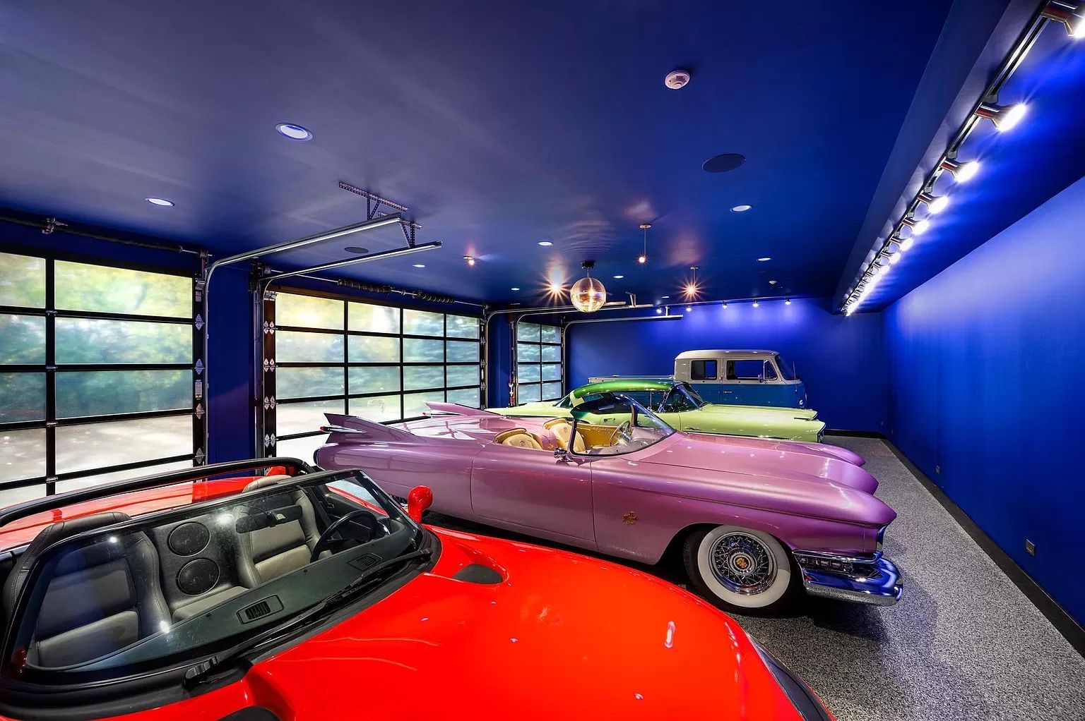 A garage with four classic cars.