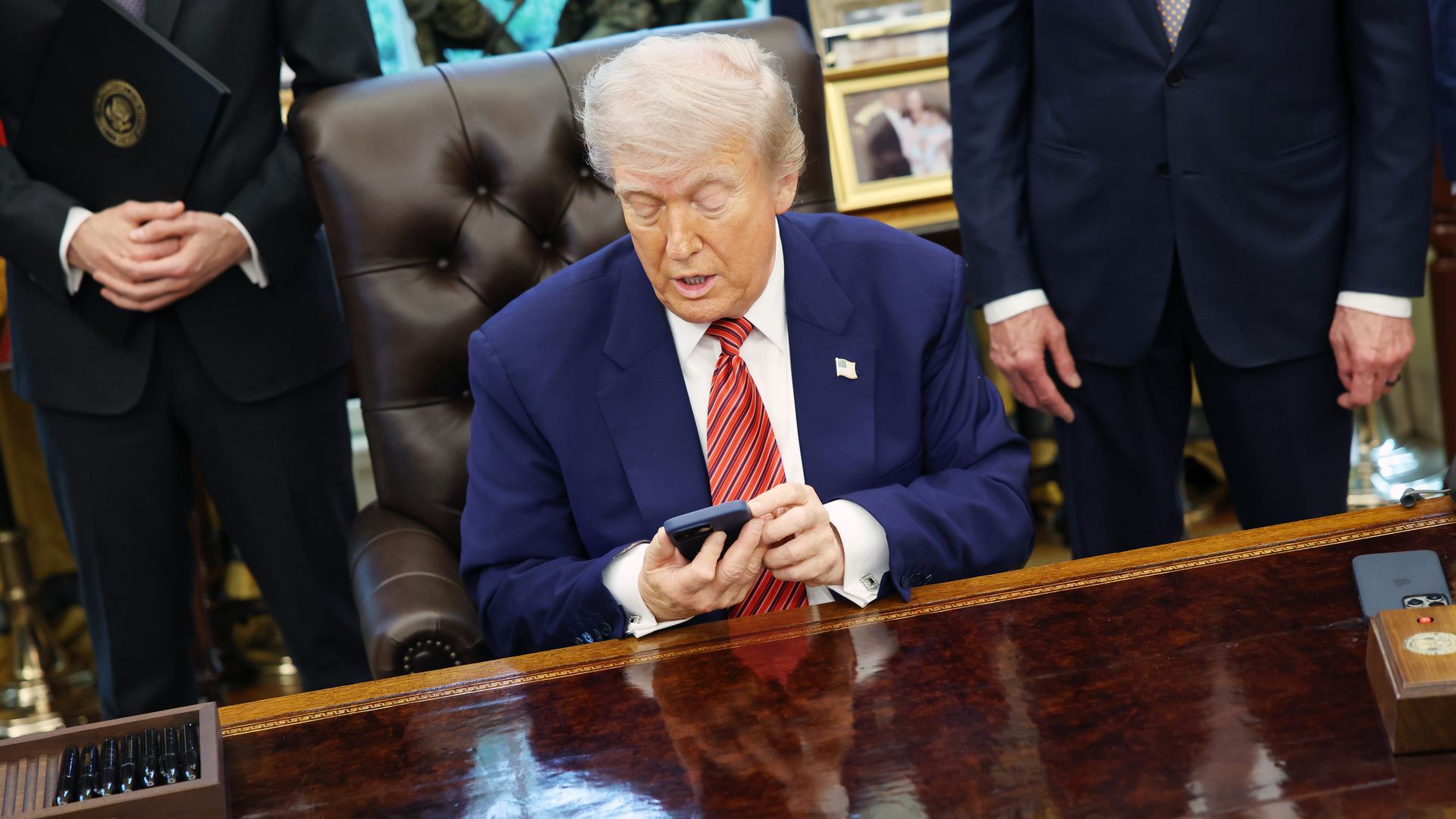 Trump with cell phone at desk