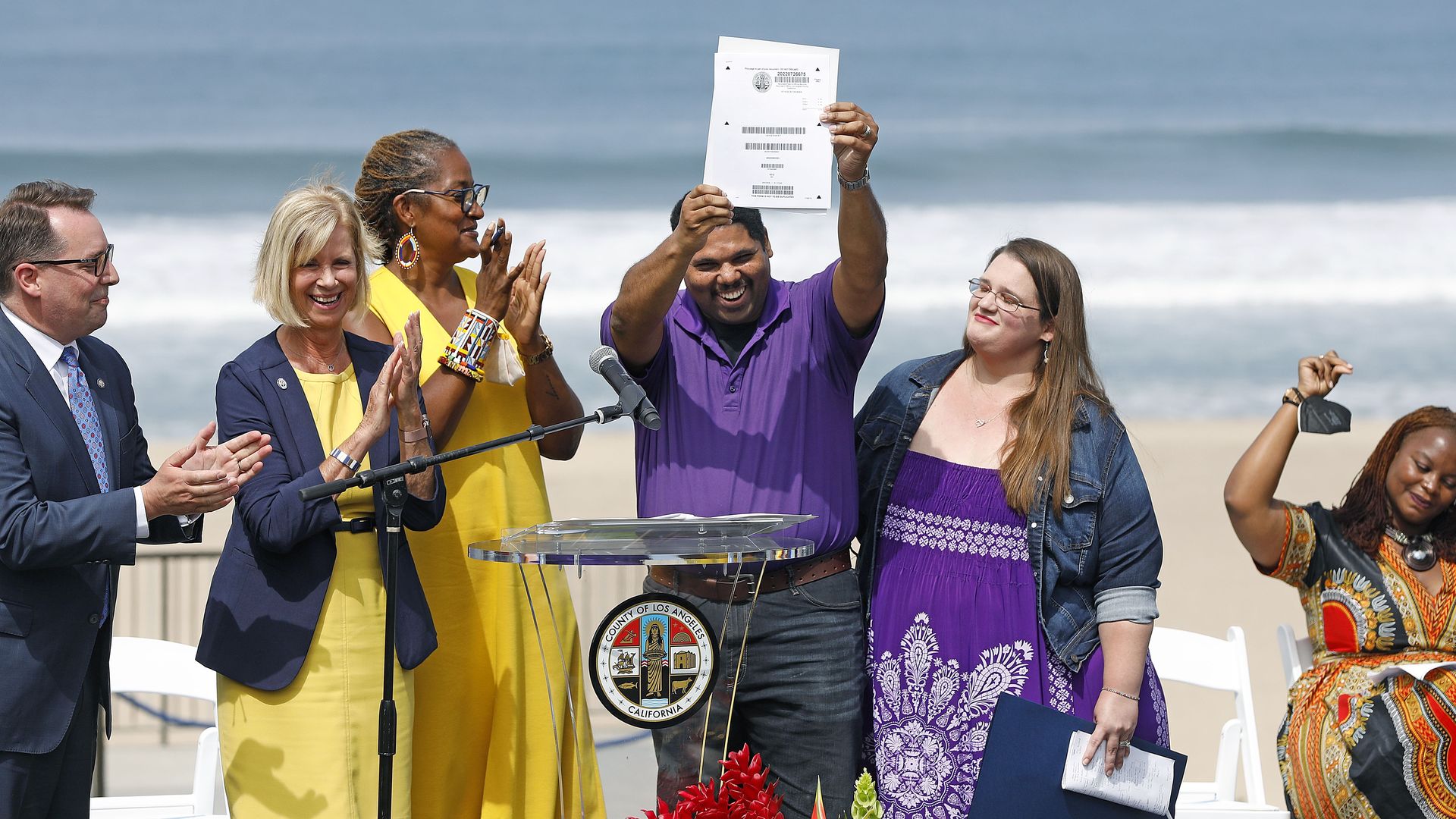 Anthony Bruce, a descendant of the Roaring 20's owners, holds up the beach deed during yesterday's ceremony.