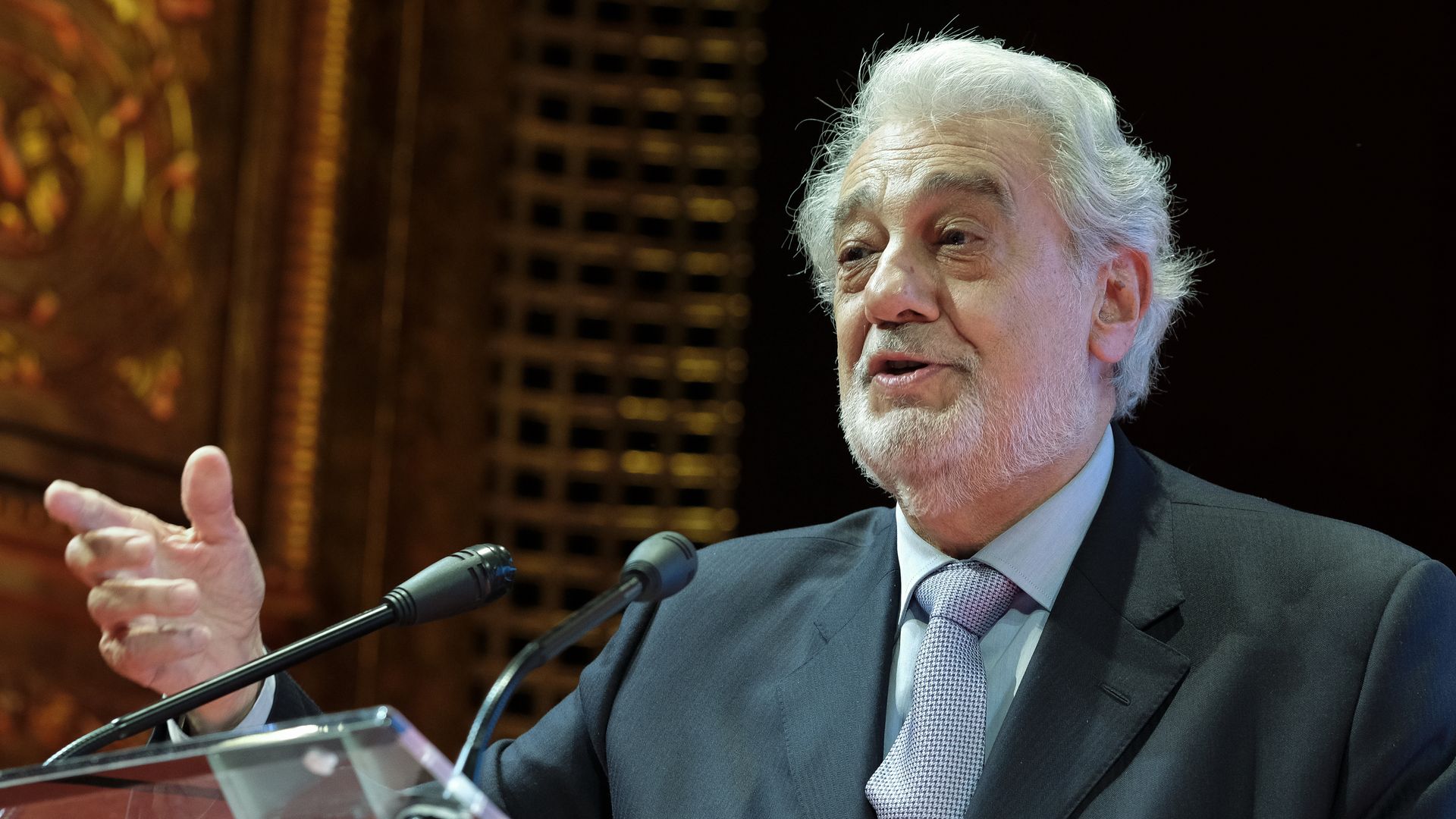 In this image, Domingo stands and speaks at a podium.