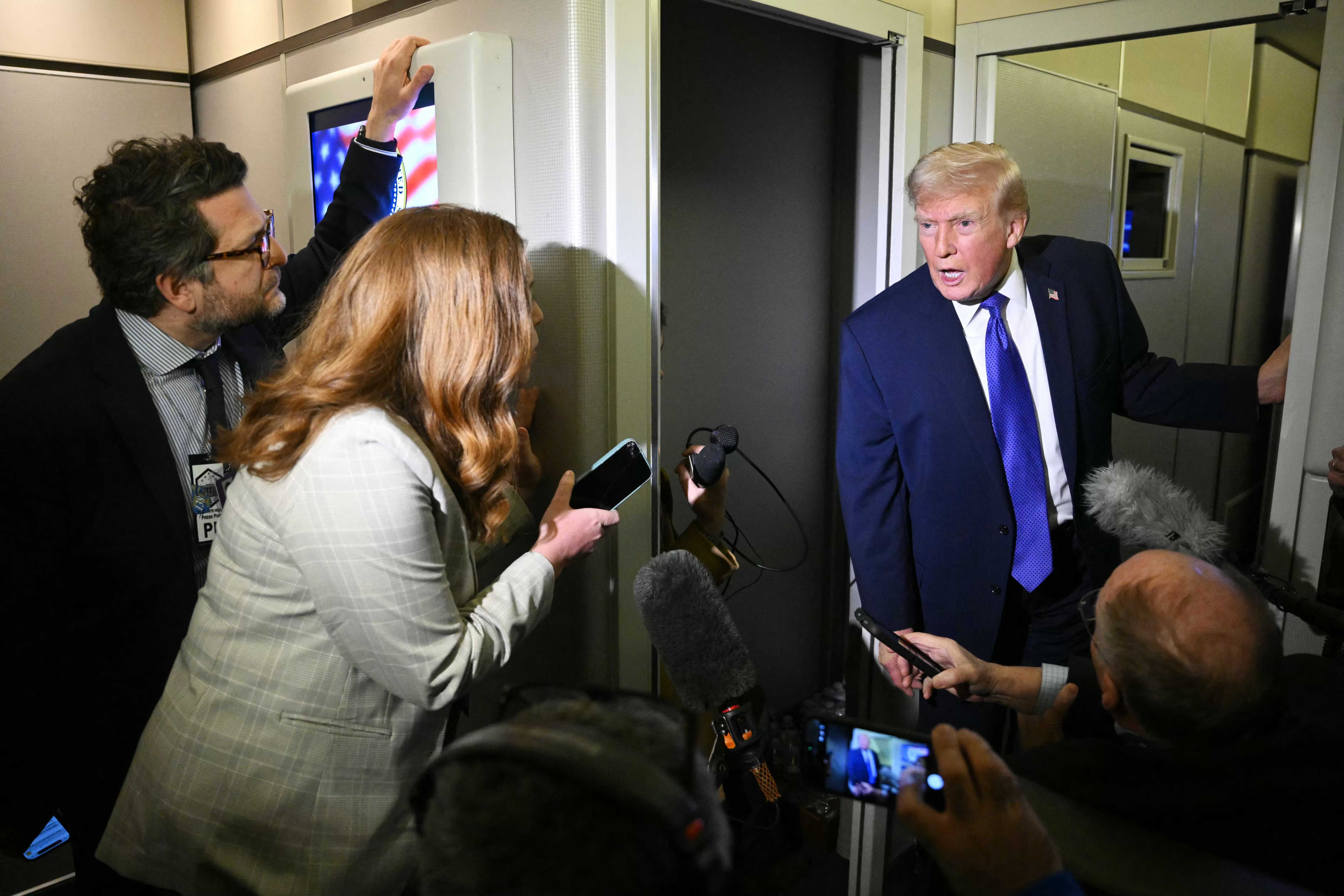President Trump talks to reporters on Air Force One en route from Palm Beach to Washington last night.