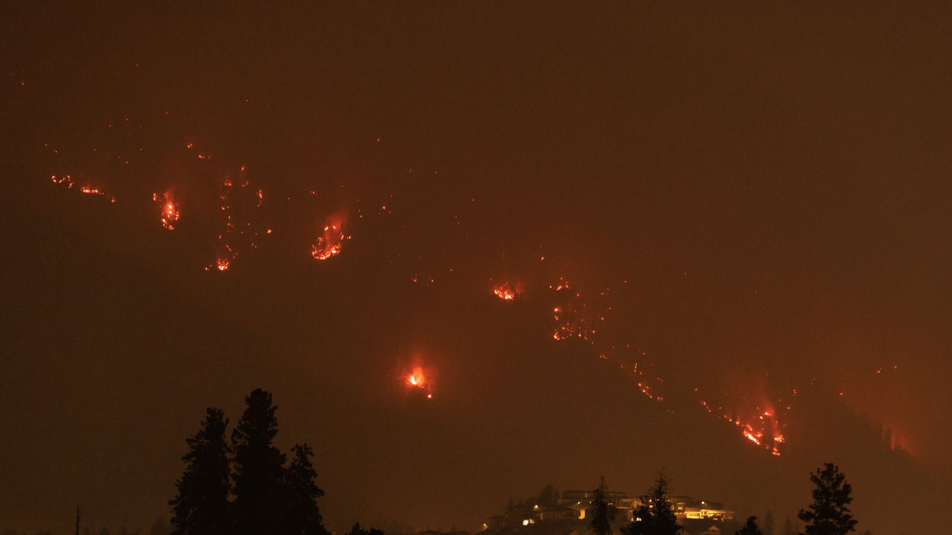 Fires burning at night outside of West Kelowna, British Columbia.