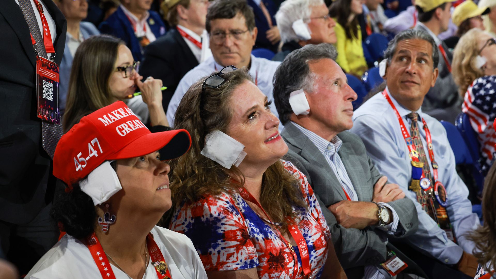  People wear "bandages" on their ears as they watch on the third day of the Republican National Convention at the Fiserv Forum on July 17, 2024 in Milwaukee, Wisconsin. 