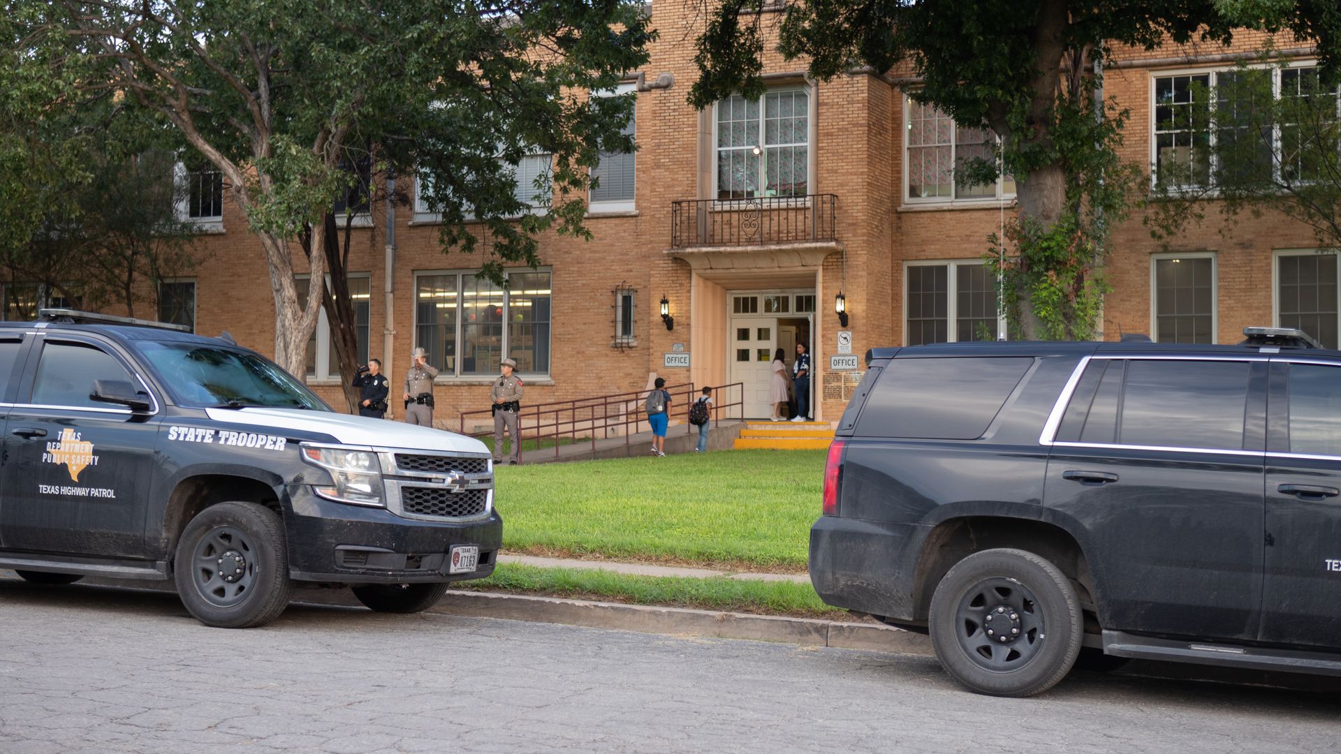 Kids walk past two law enforcement on their way into school as students go back to school months after deadly US shooting in Uvalde, Texas.