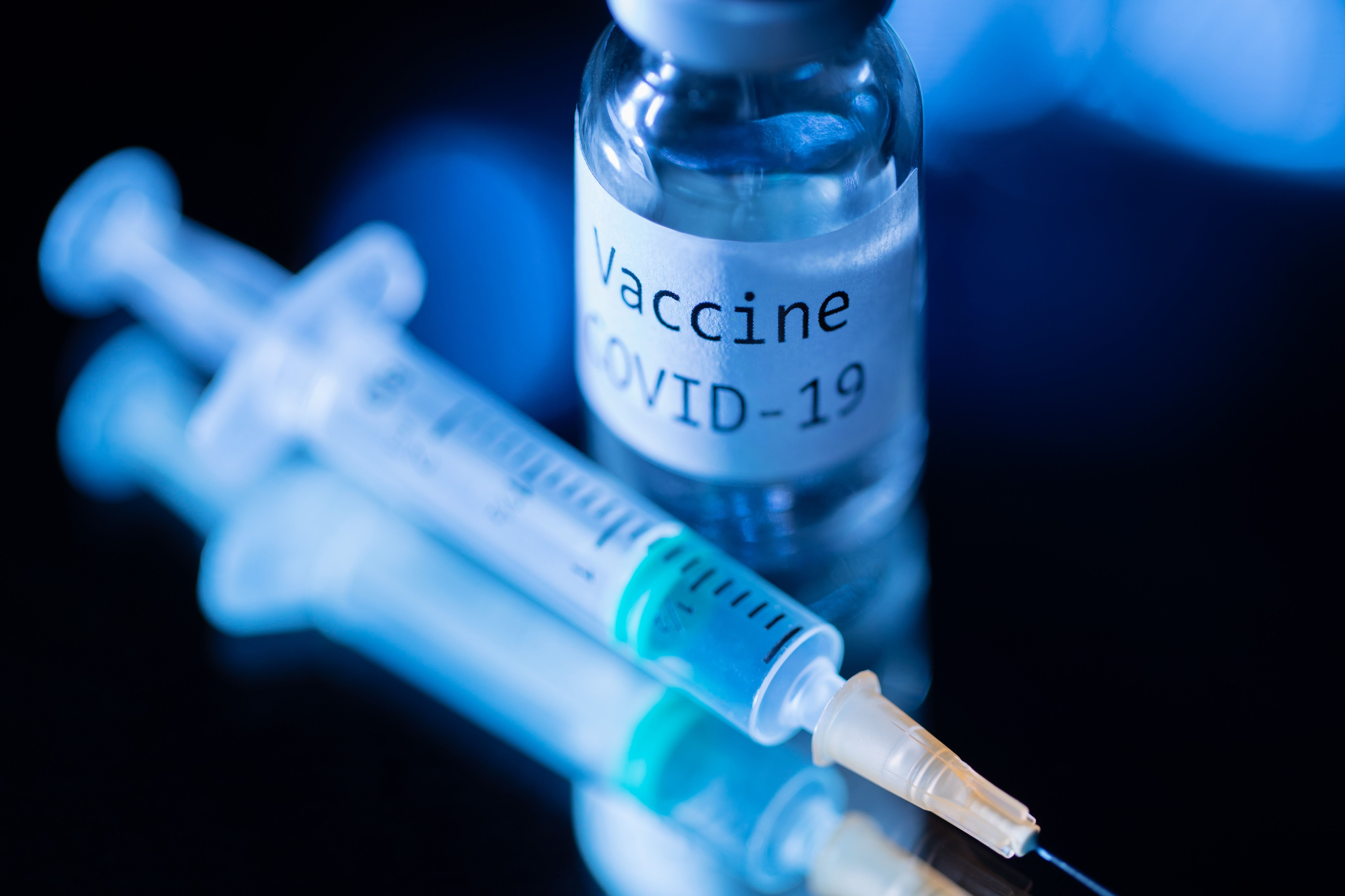 This picture taken on November 17, 2020 shows a syringe and a bottle reading "Vaccine Covid-19". 