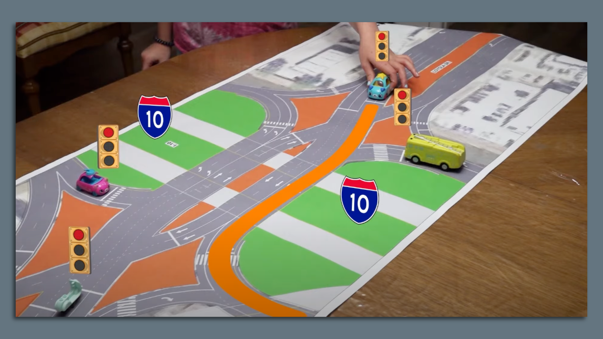 Photo shows a kid using toy cars to navigate a diverging diamond intersection