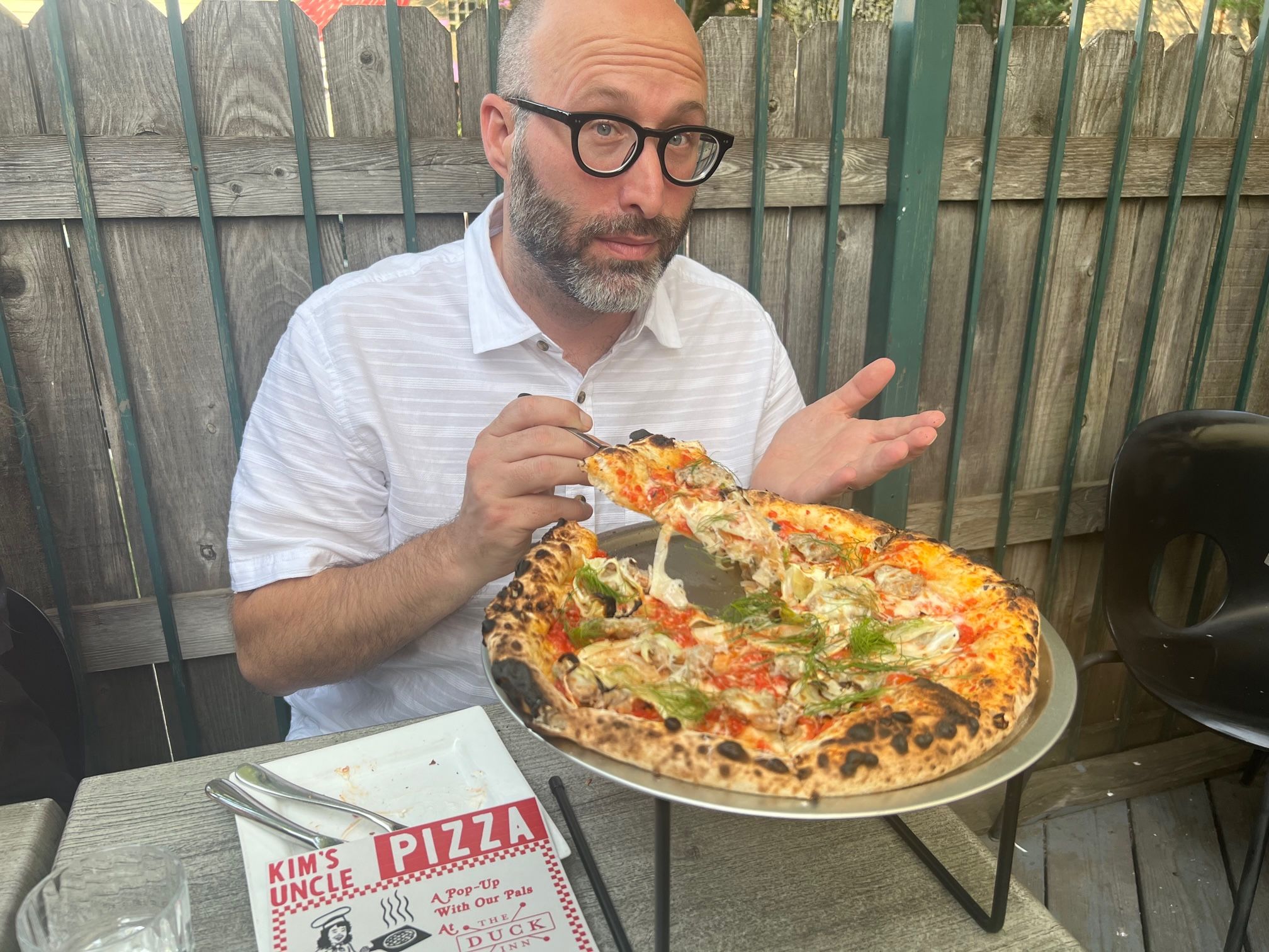 Photo of a man in front of a pizza 