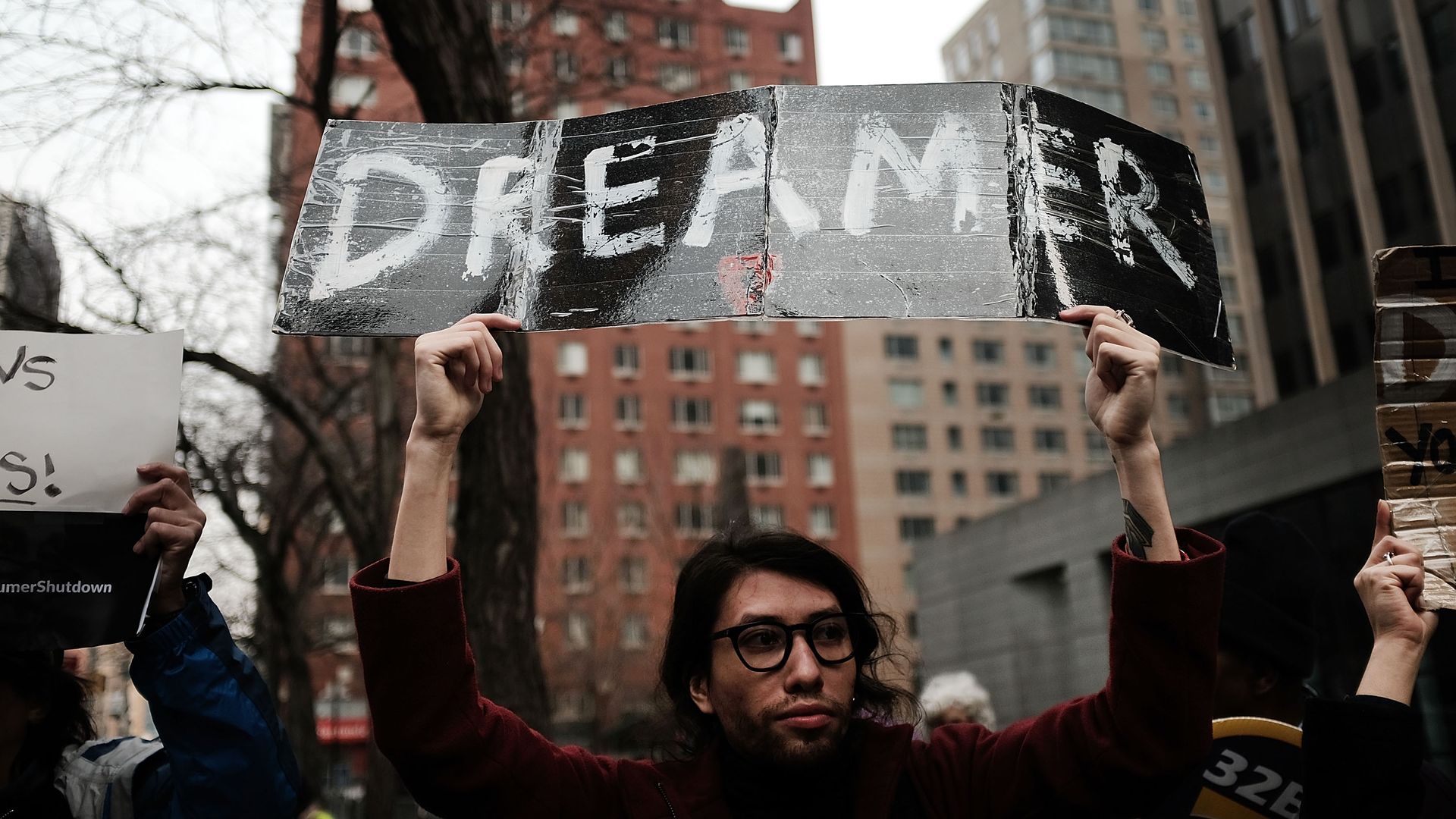 A demonstrator protests, holding a sign that says "DREAMER." 