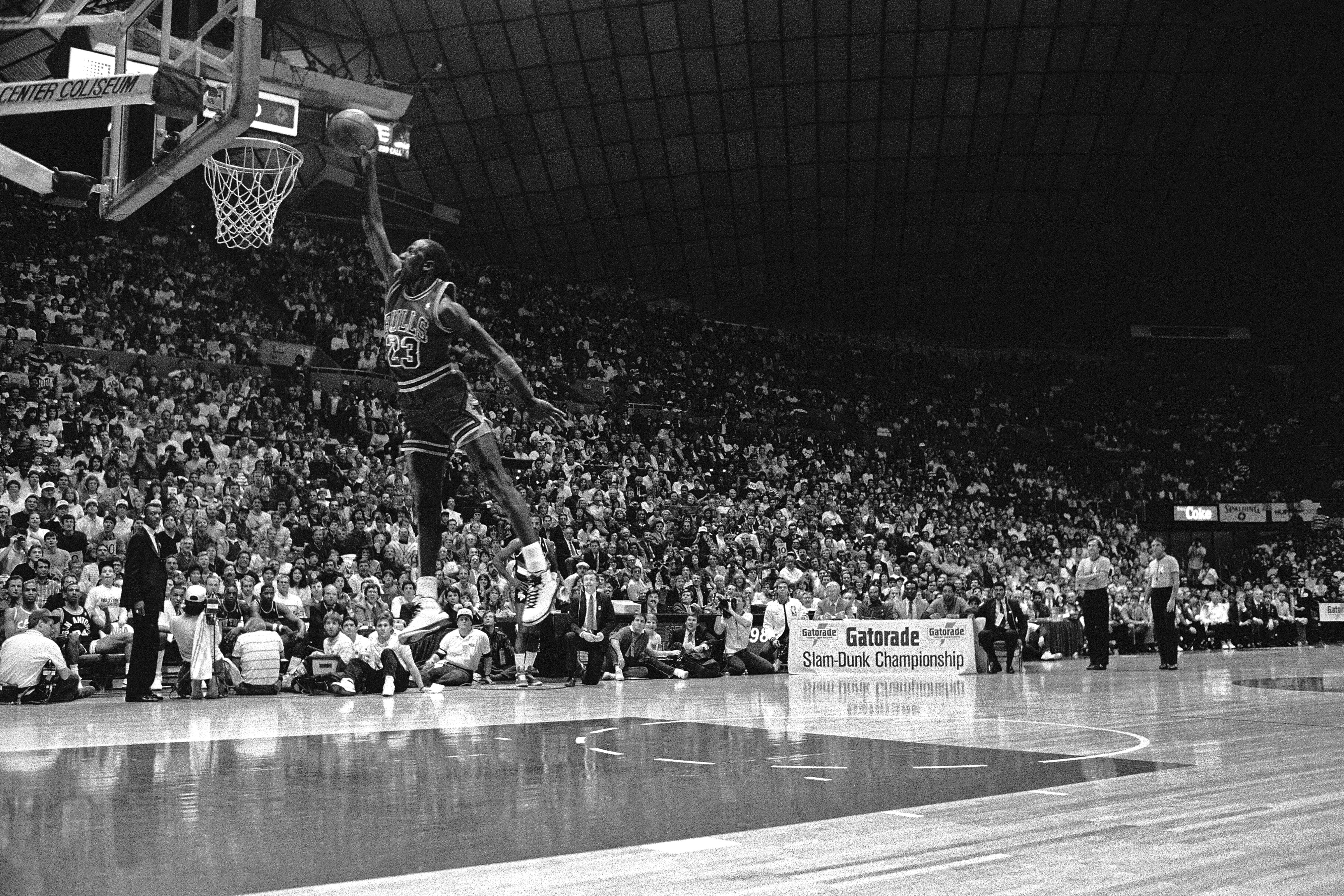 Photo of a man jumping towards a basketball hoop
