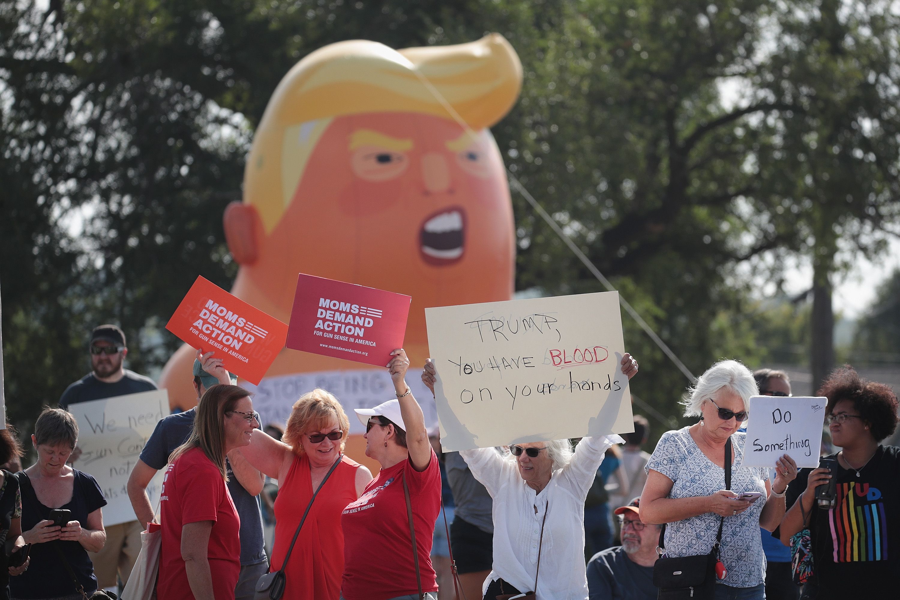 Demonstrators line the street near Miami Valley Hospital in anticipation of a visit from President Donald Trump