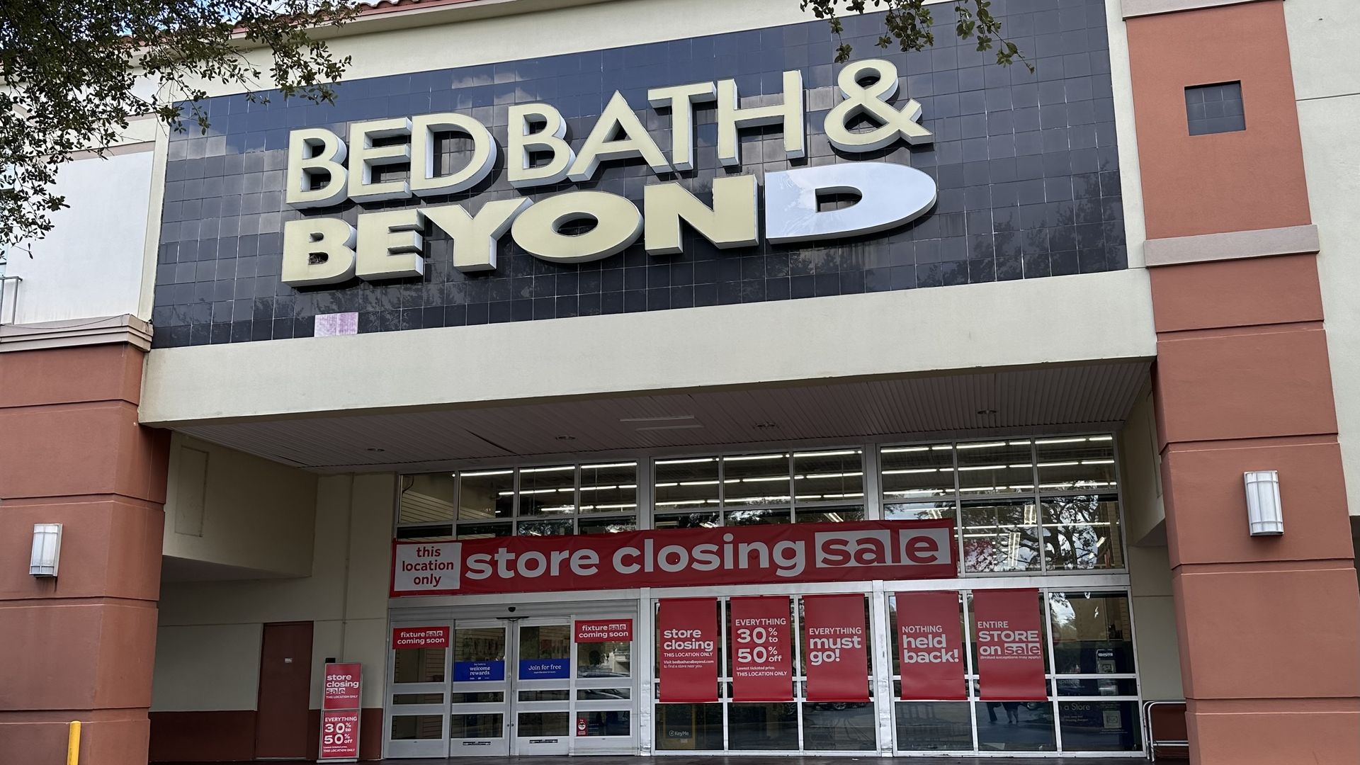 Bed Bath & Beyond storefront with signs reading “store closing sale.”