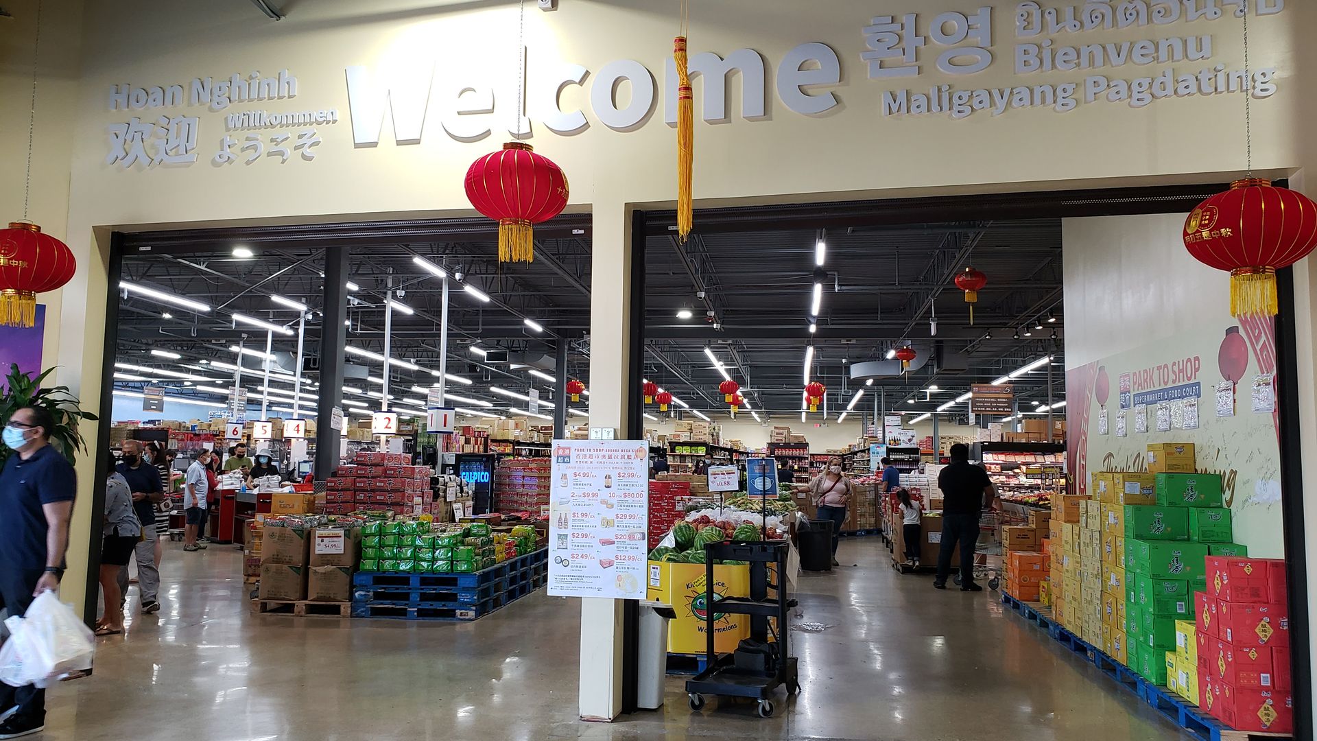 A welcome sign above an entrance to a grocery store. 