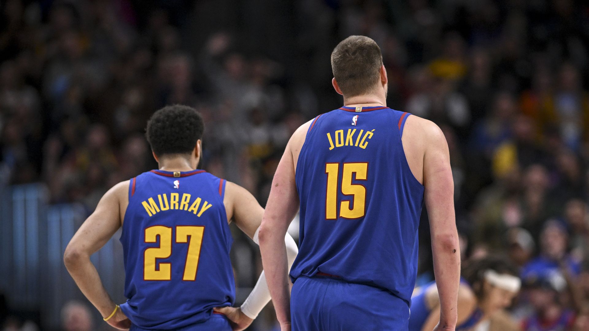 Two players in blue uniforms for the Denver Nuggets stand next to each other