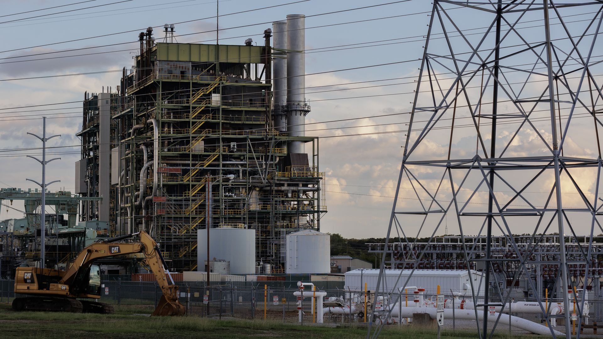 An energy facility with pipes and construction vehicles around it