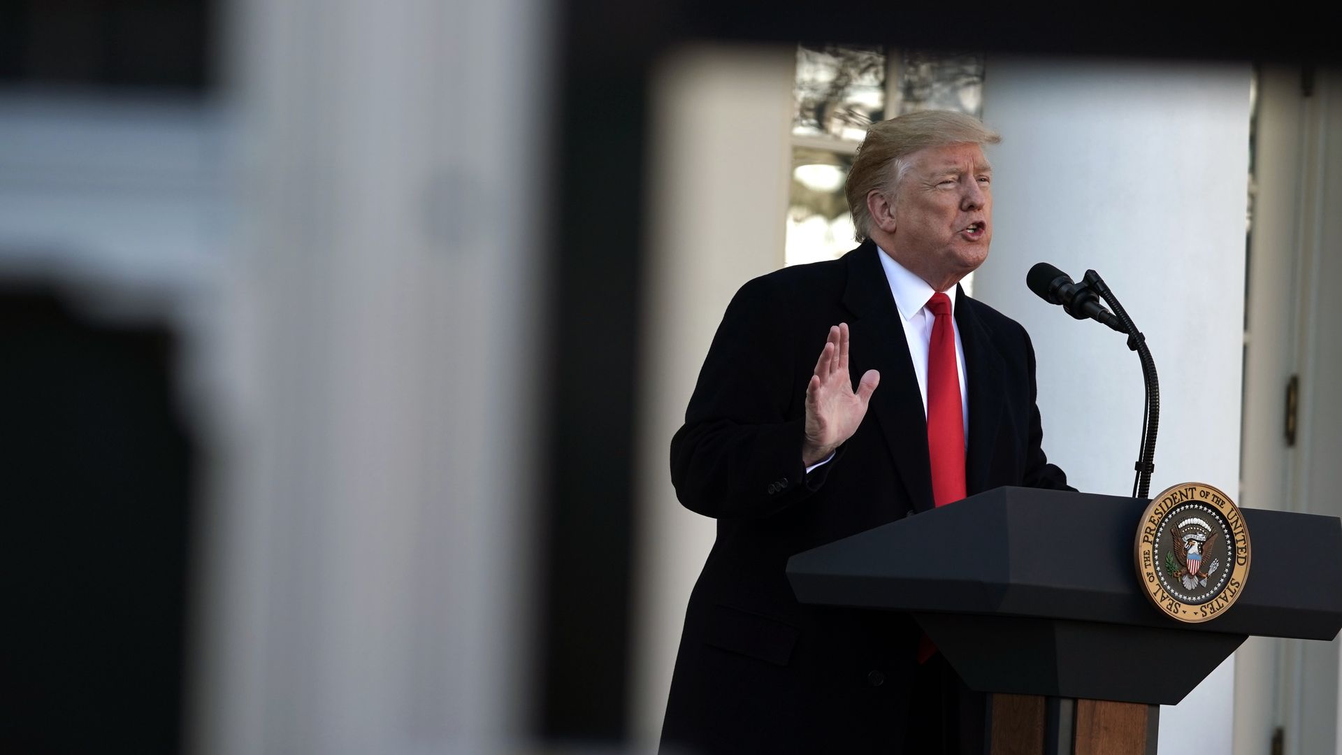 Donald Trump at podium gestures.
