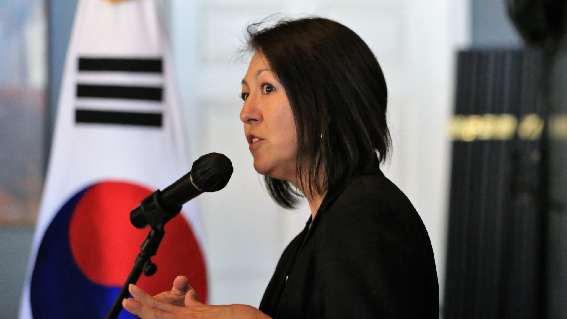 Female candidate speaks in front of a microphone.
