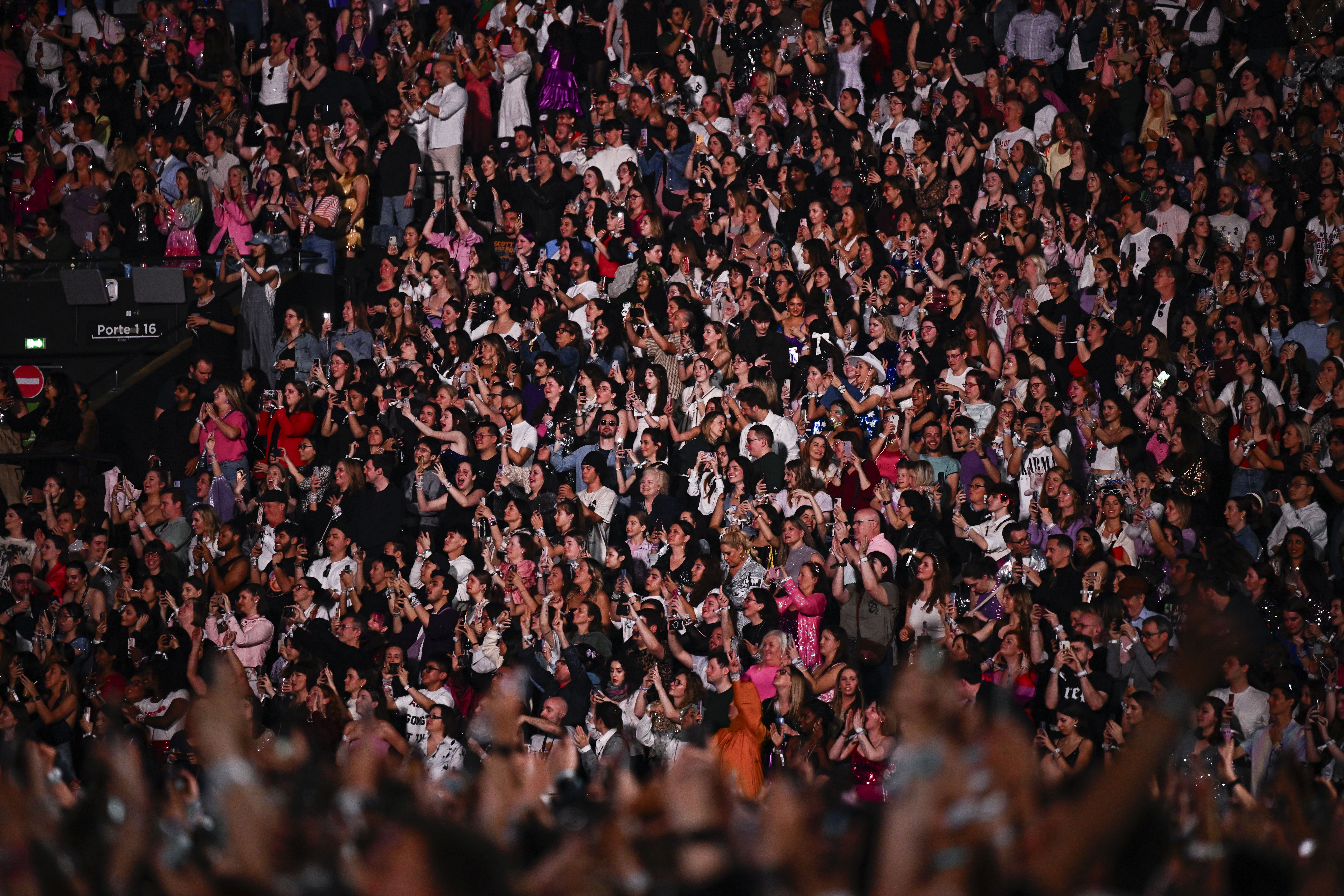 Spectators cheers as US singer and songwriter Taylor Alison Swift, also known as Taylor Swift performs on stage at the Paris La Defense Arena as part of her The Eras Tour, in Nanterre, north-western France
