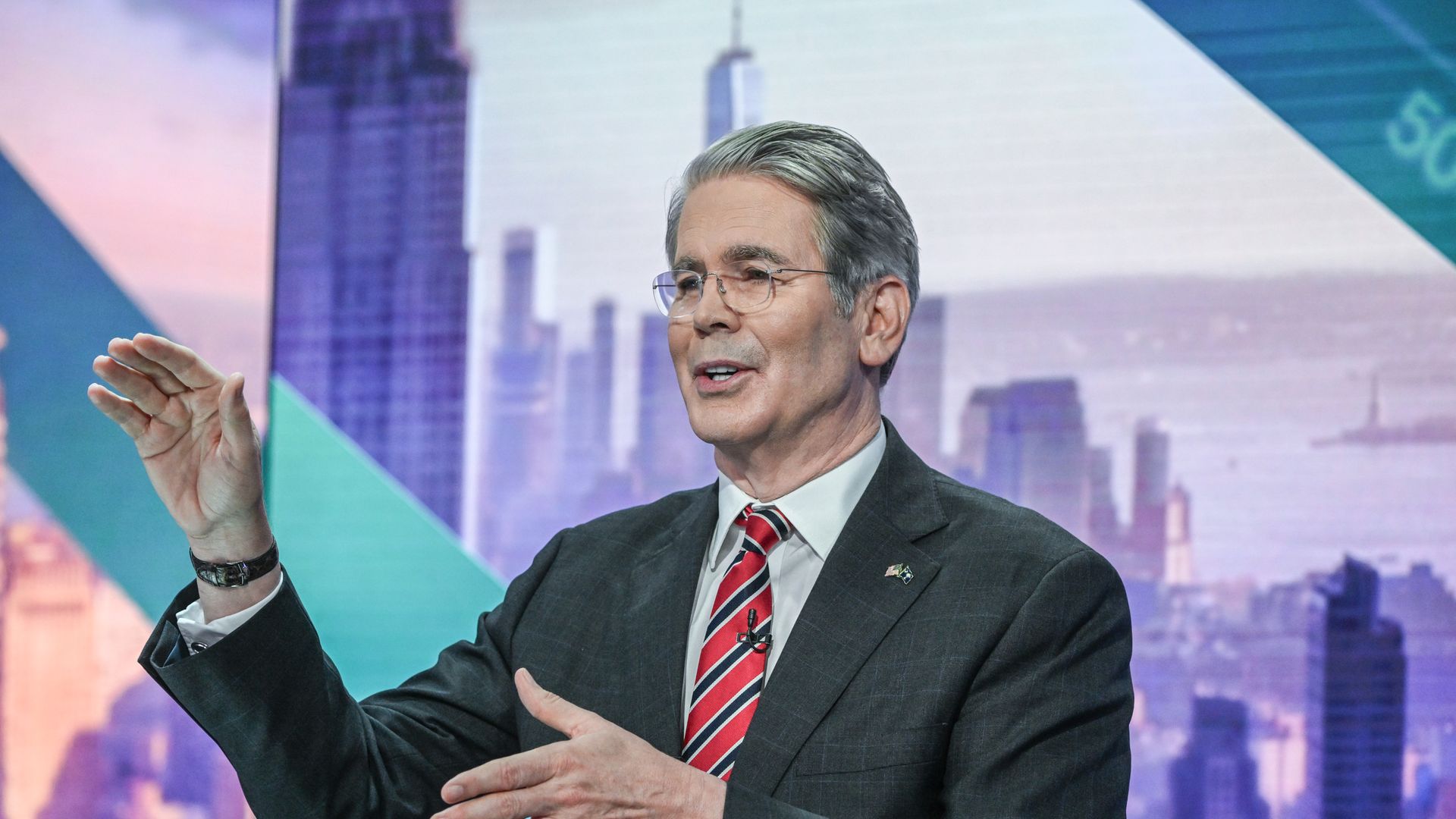 Treasury Secretary Scott Bessent gestures with both hands during a TV interview.
