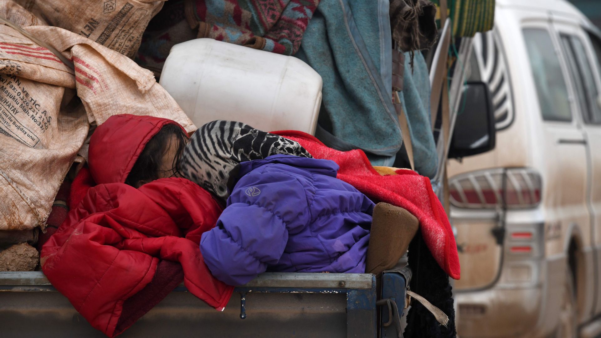 Syrian refugee children sleeping in the back of a truck